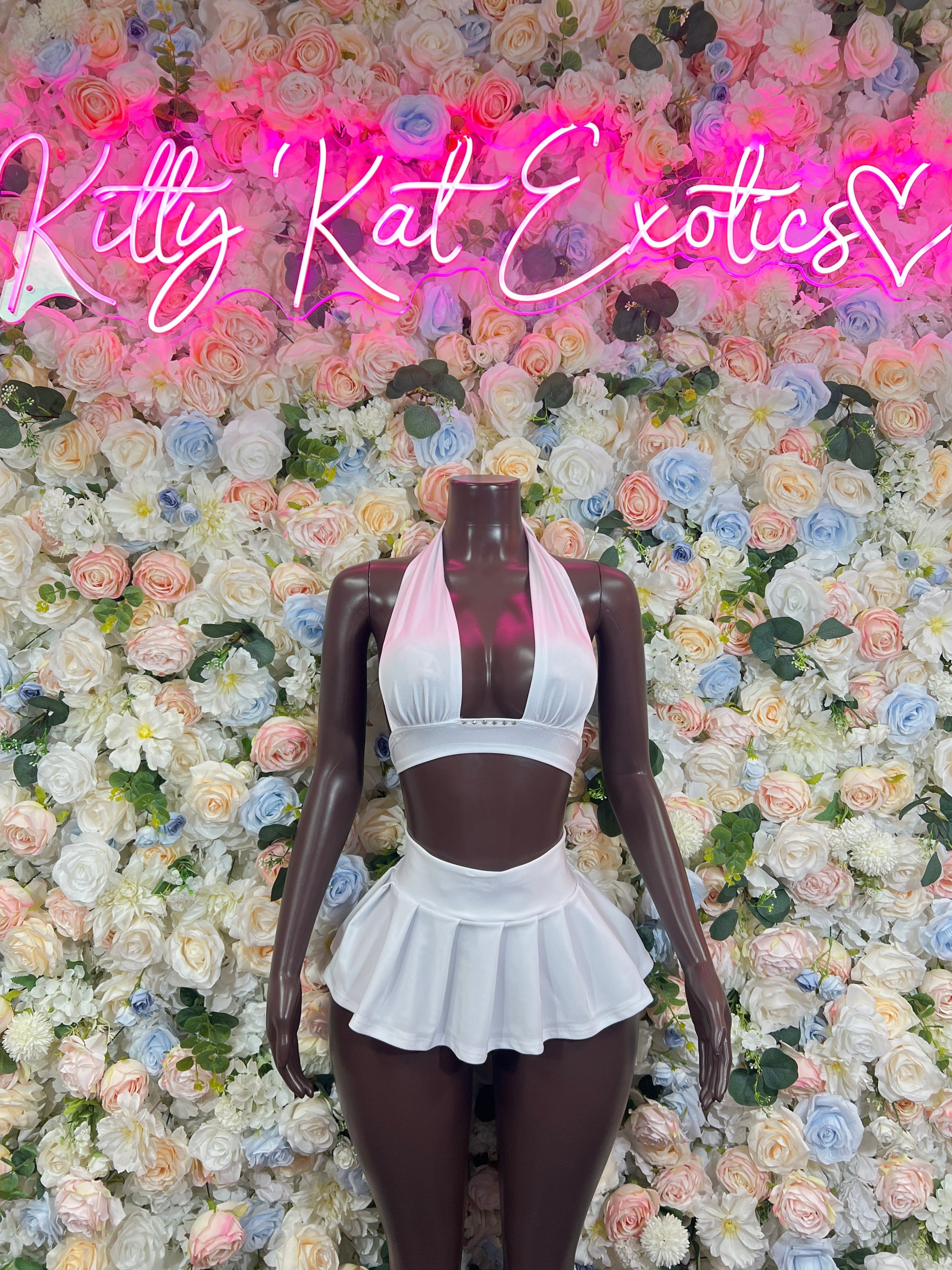 White two-piece rave set with halter crop top and ruffled mini skirt, front view