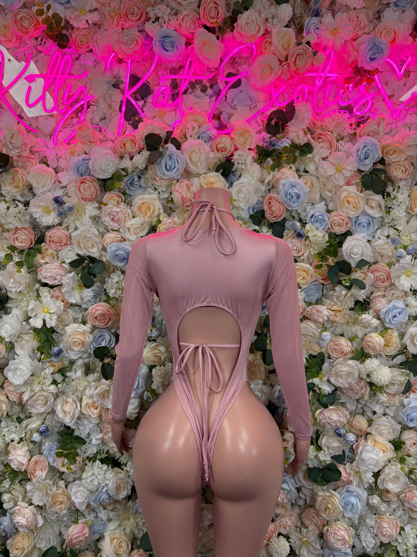 Rose pink velvet bodysuit with long sleeves and lace-up cutout back