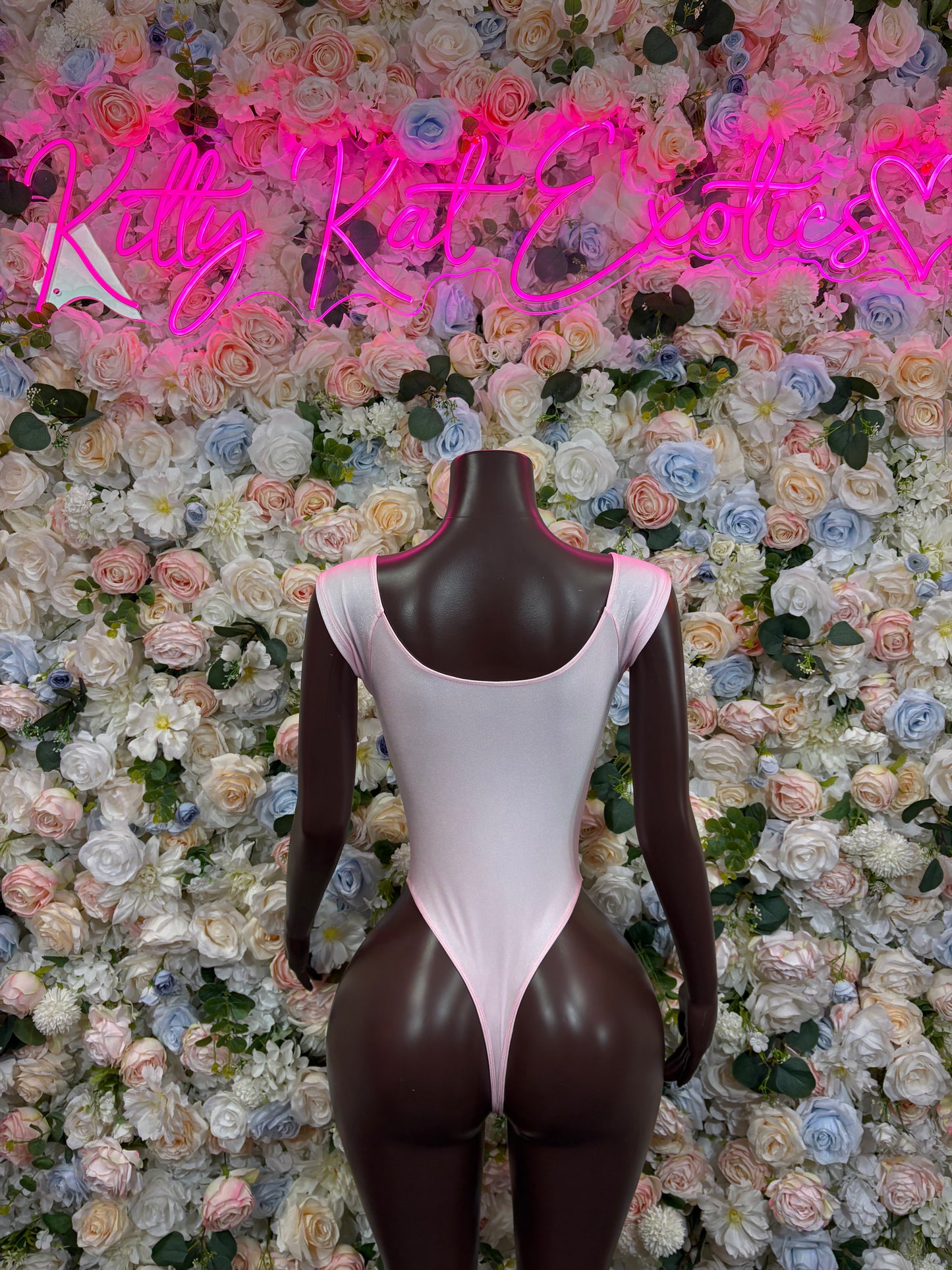 Light pink one-piece bodysuit with strappy back and high-cut legs