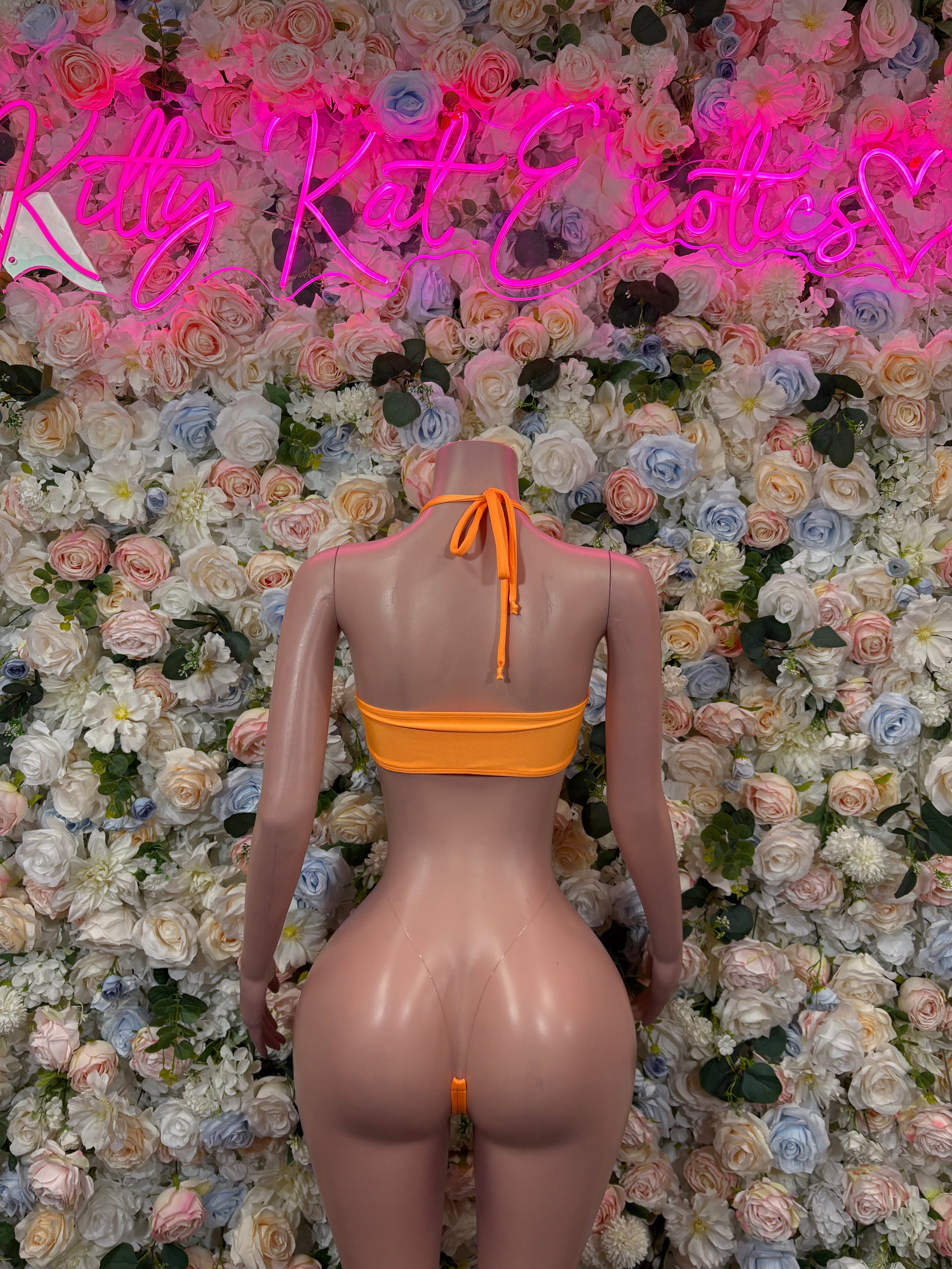Orange one-piece bodysuit with open back and tie straps