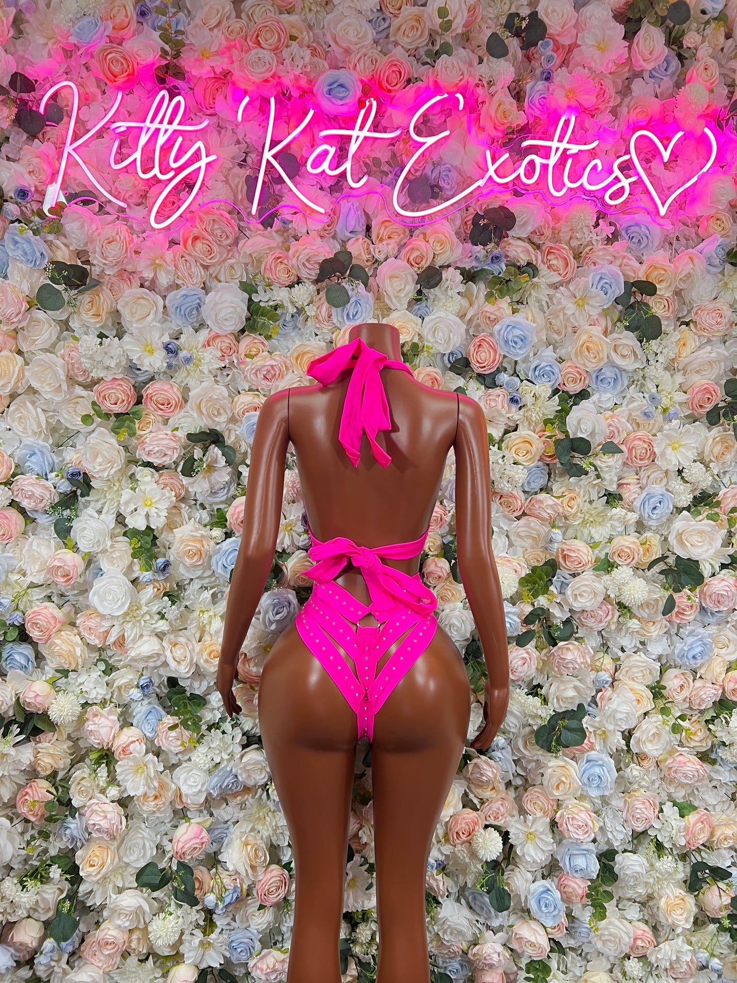 Pink strappy bodysuit with open back and high-cut legs