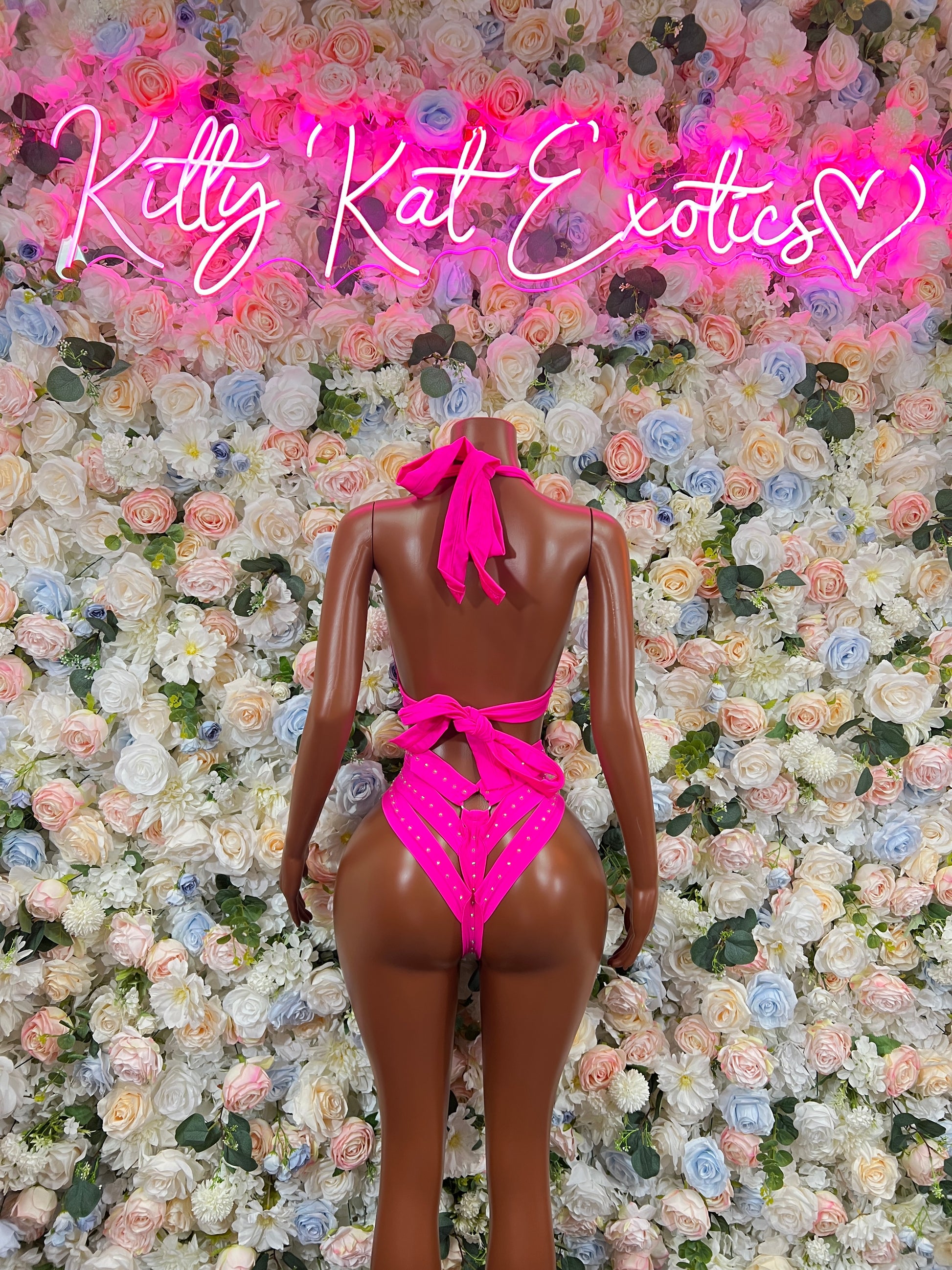 Pink strappy bodysuit with open back and high-cut legs