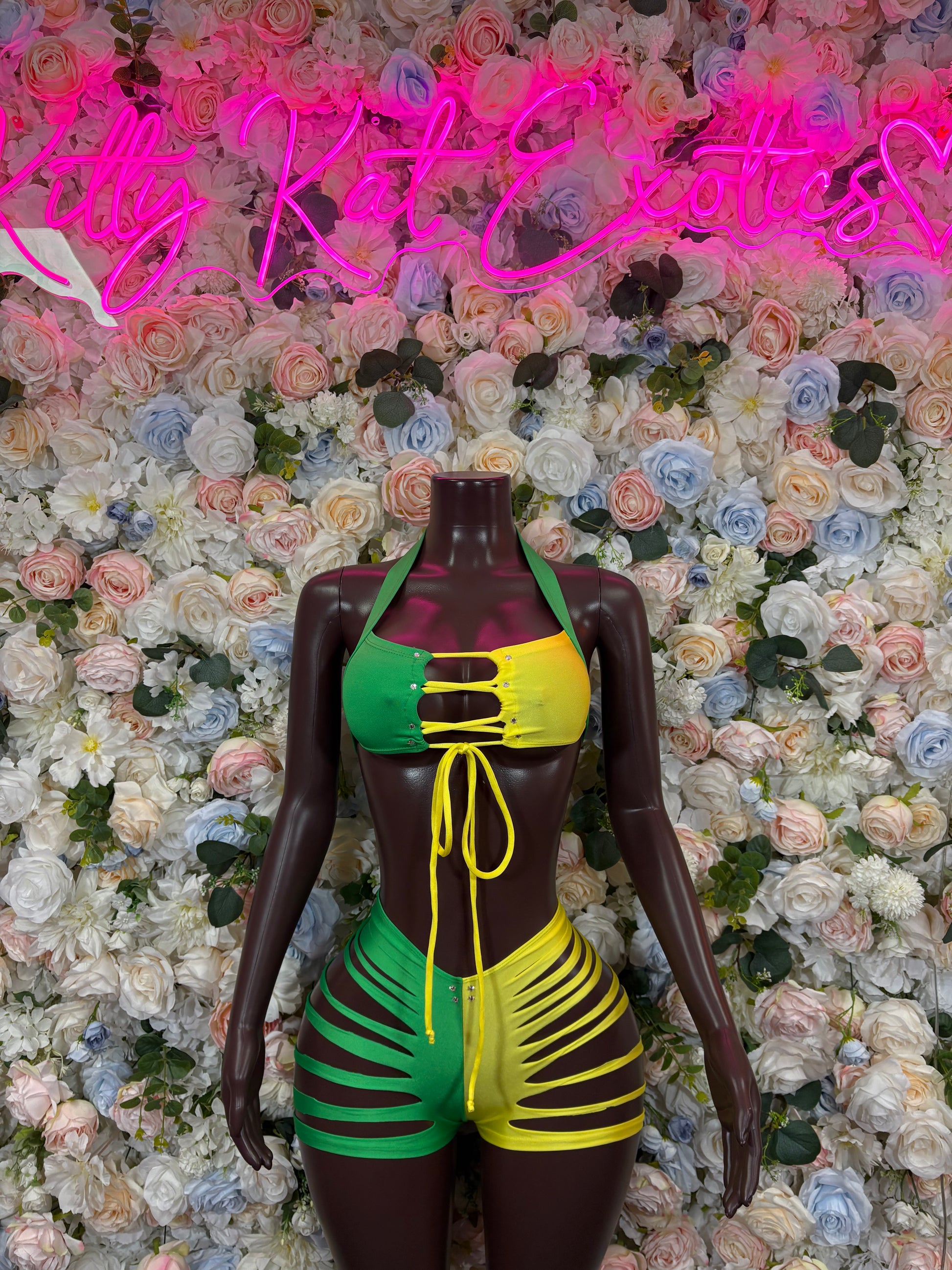 Two-piece bikini with green, yellow, and black striped fabric on mannequin