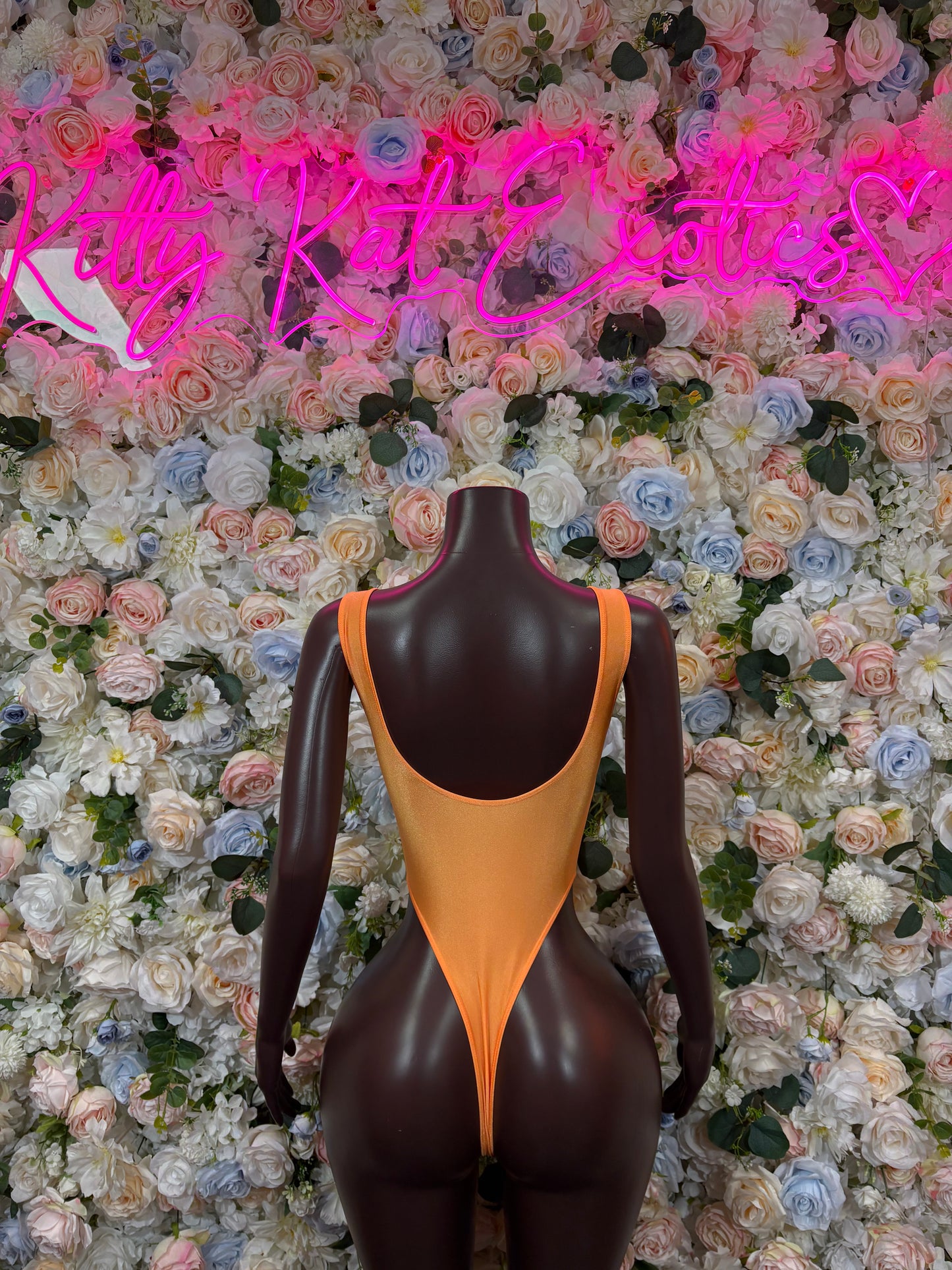 Orange fishnet bodysuit with open back and high-cut leg openings