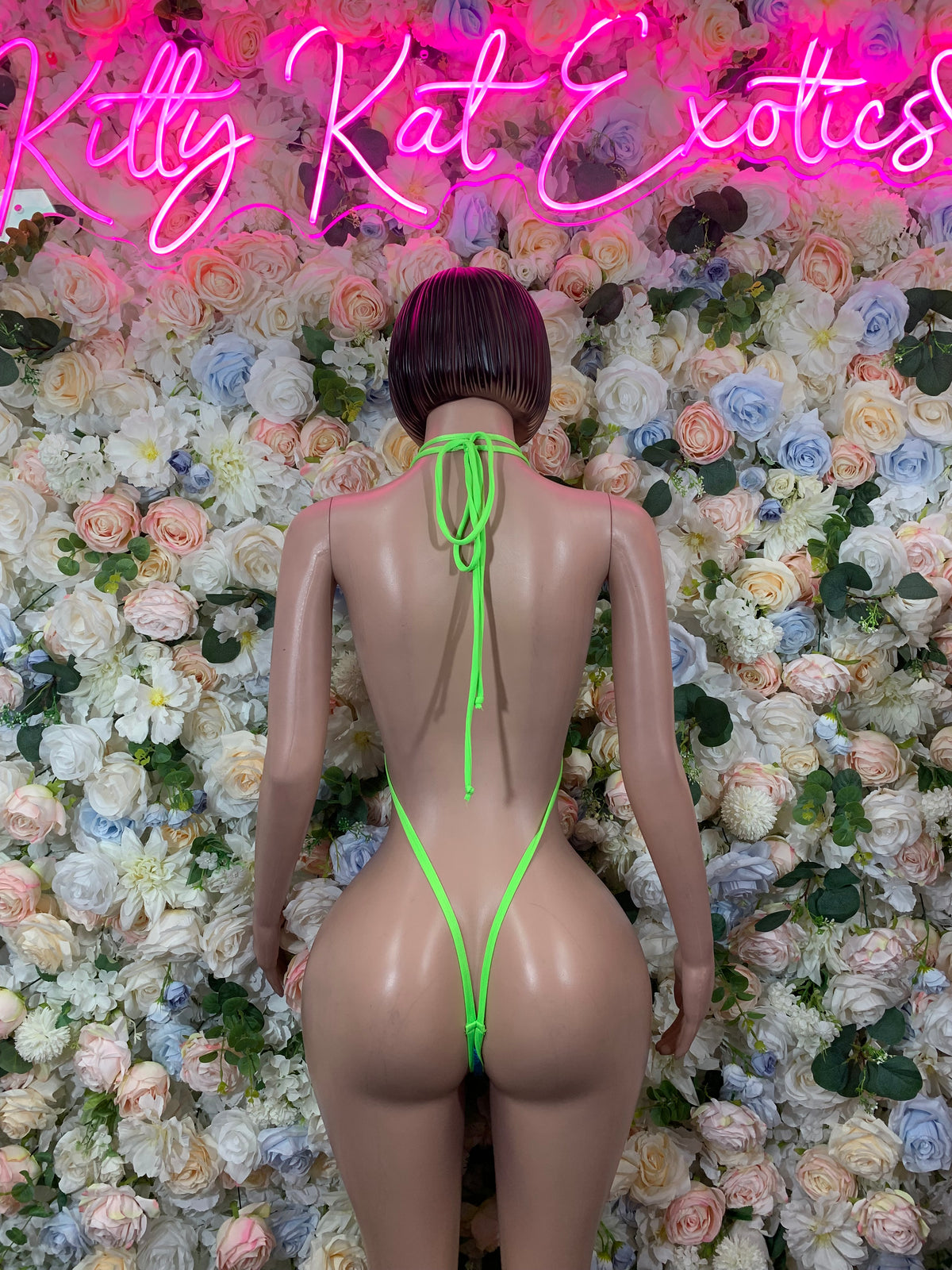 Neon green slingshot bodysuit with back strap and tie closure, thong-style fit