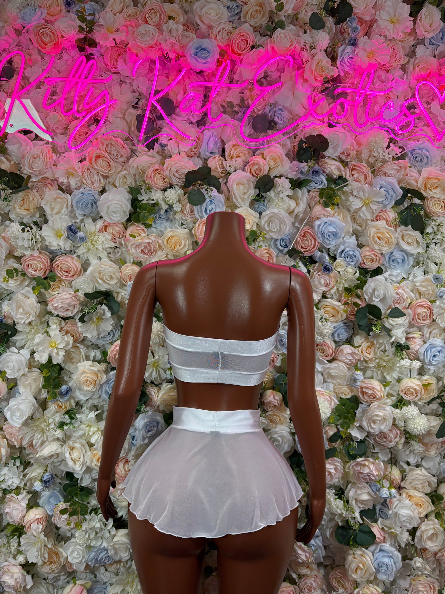 White strapless bra and pleated mini skirt two-piece set, back view on mannequin