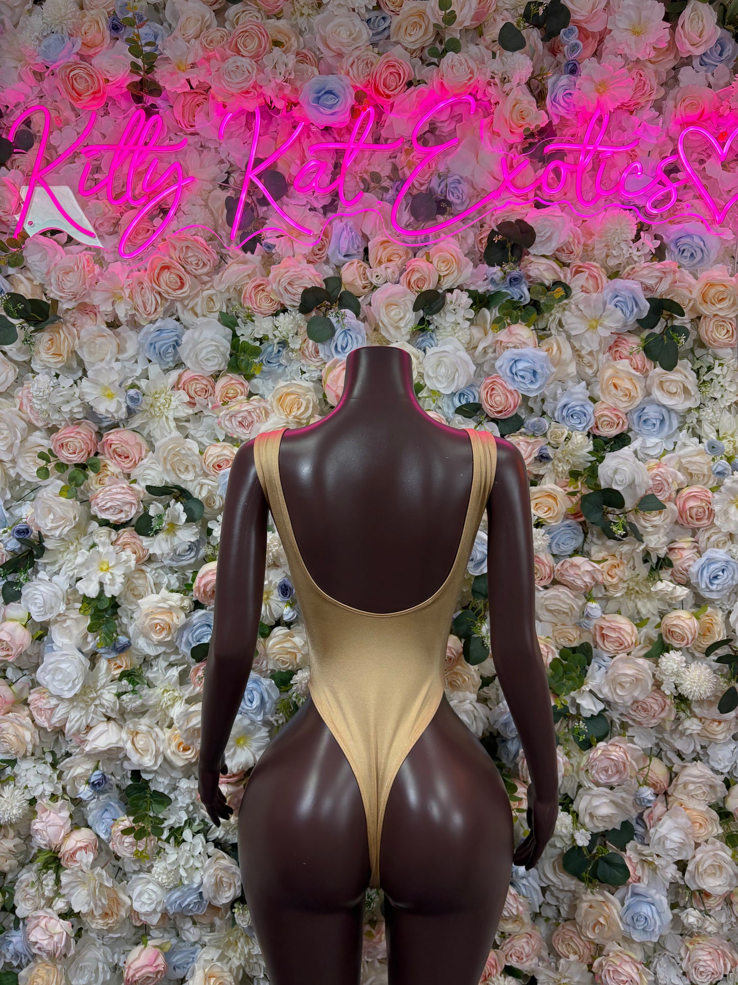 Gold one-piece bodysuit with dark high-leg cut, front view