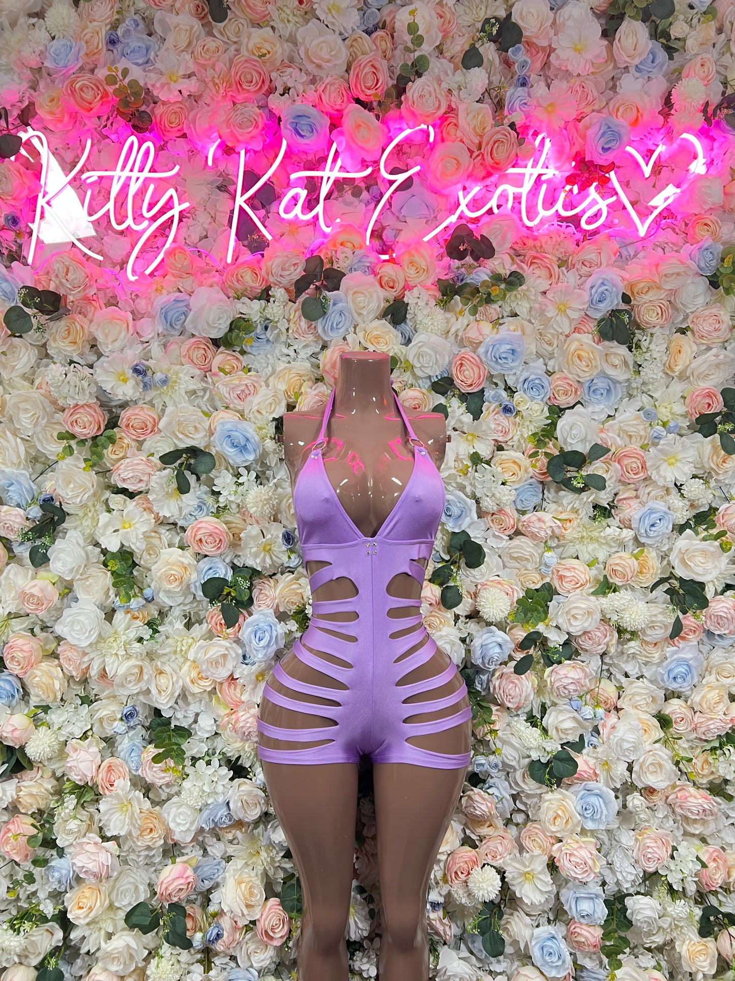Purple one-piece bodysuit with long sleeves, front V-neck, and strappy lattice cutouts