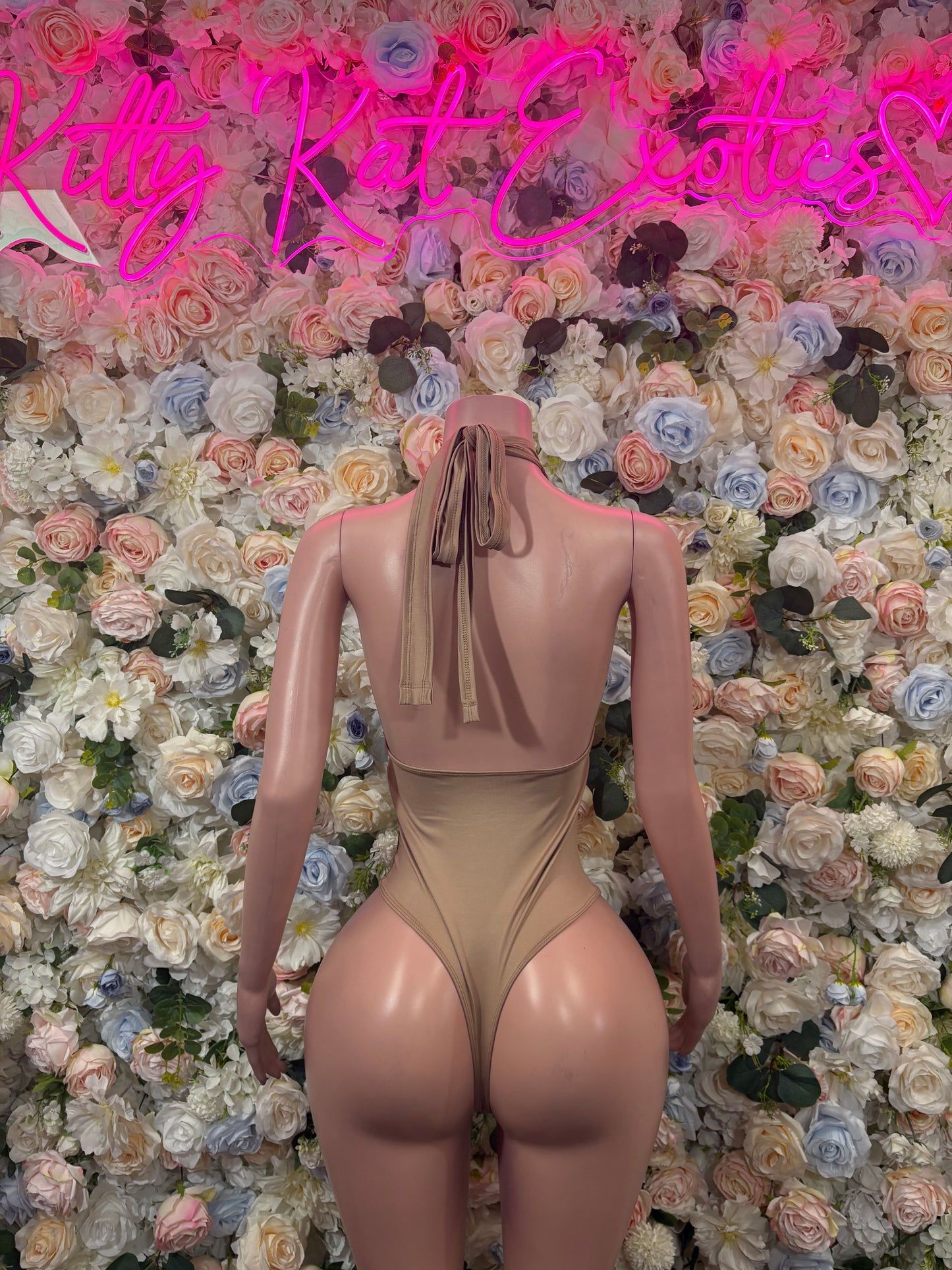 Tan open-back dancewear bodysuit with halter straps and keyhole detail