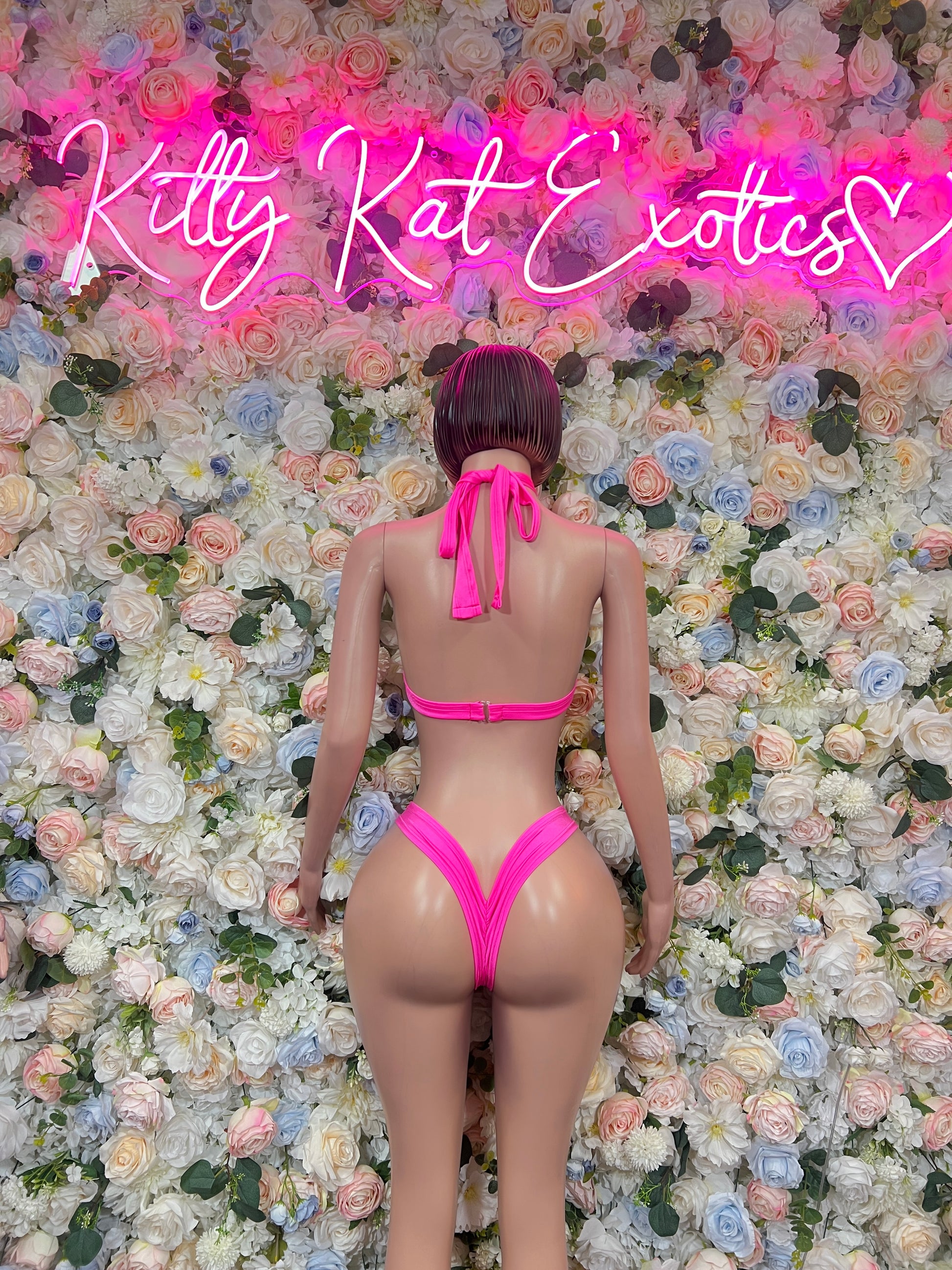 Back view of pink halter two-piece rave wear with tie straps and cheeky bottoms