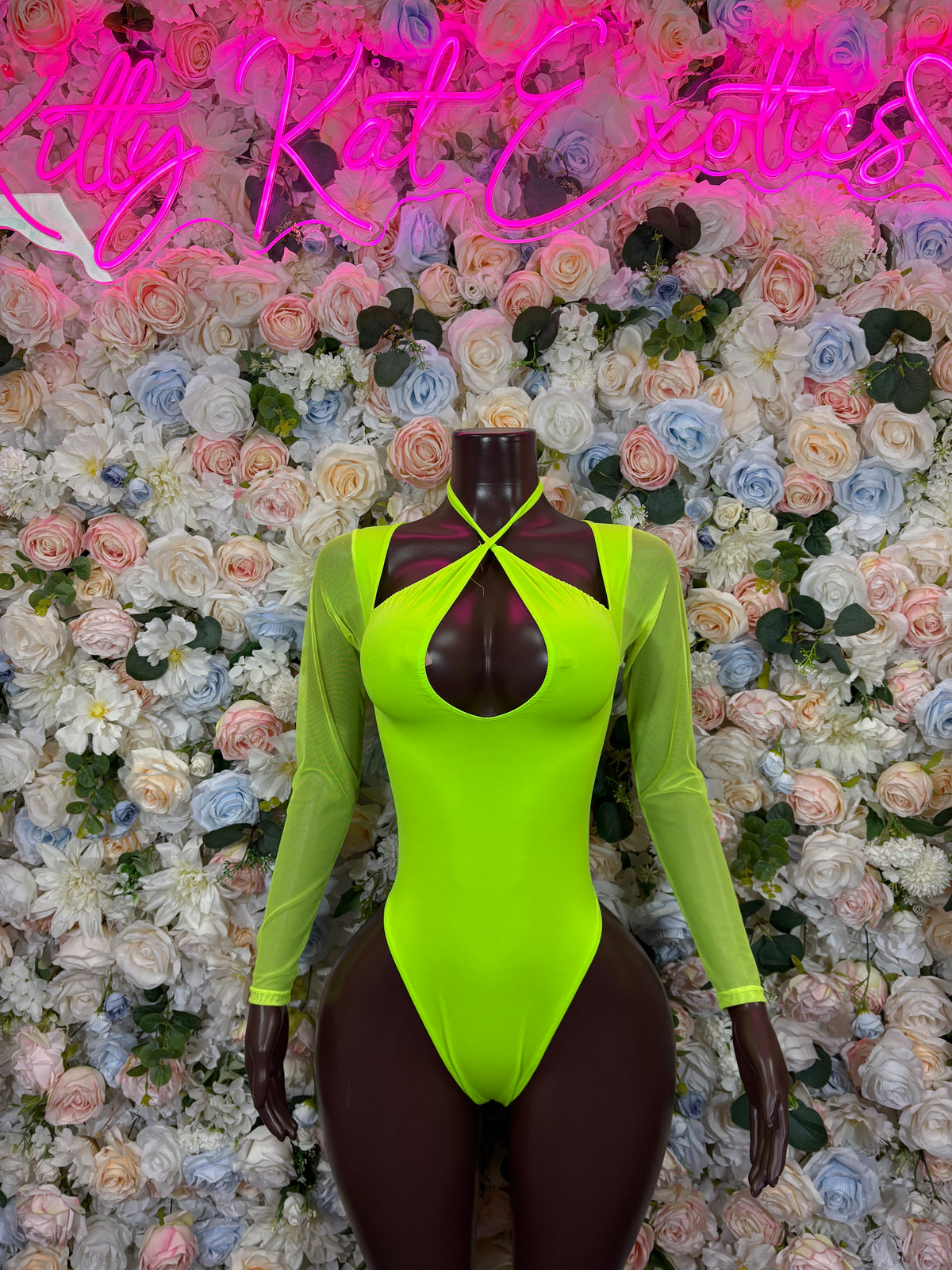 Neon green long-sleeve bodysuit with cross chest straps and black teardrop cutout