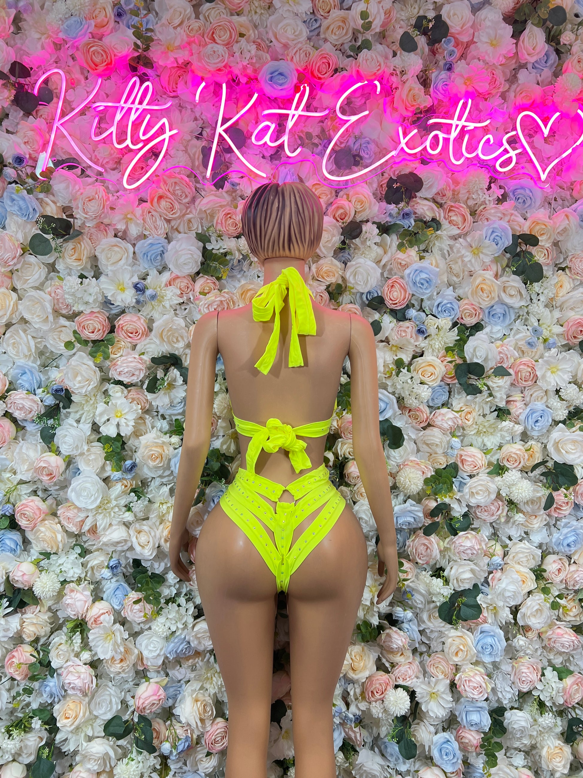 Neon green backless bodysuit with bow tie and strappy cutout back