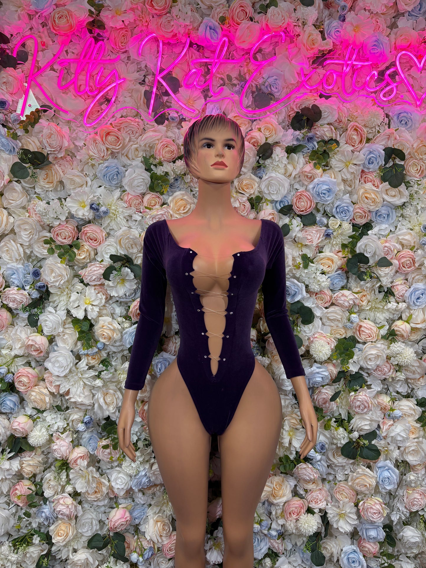 Velvet one-piece bodysuit with long sleeves and deep front V neckline, dark purple.