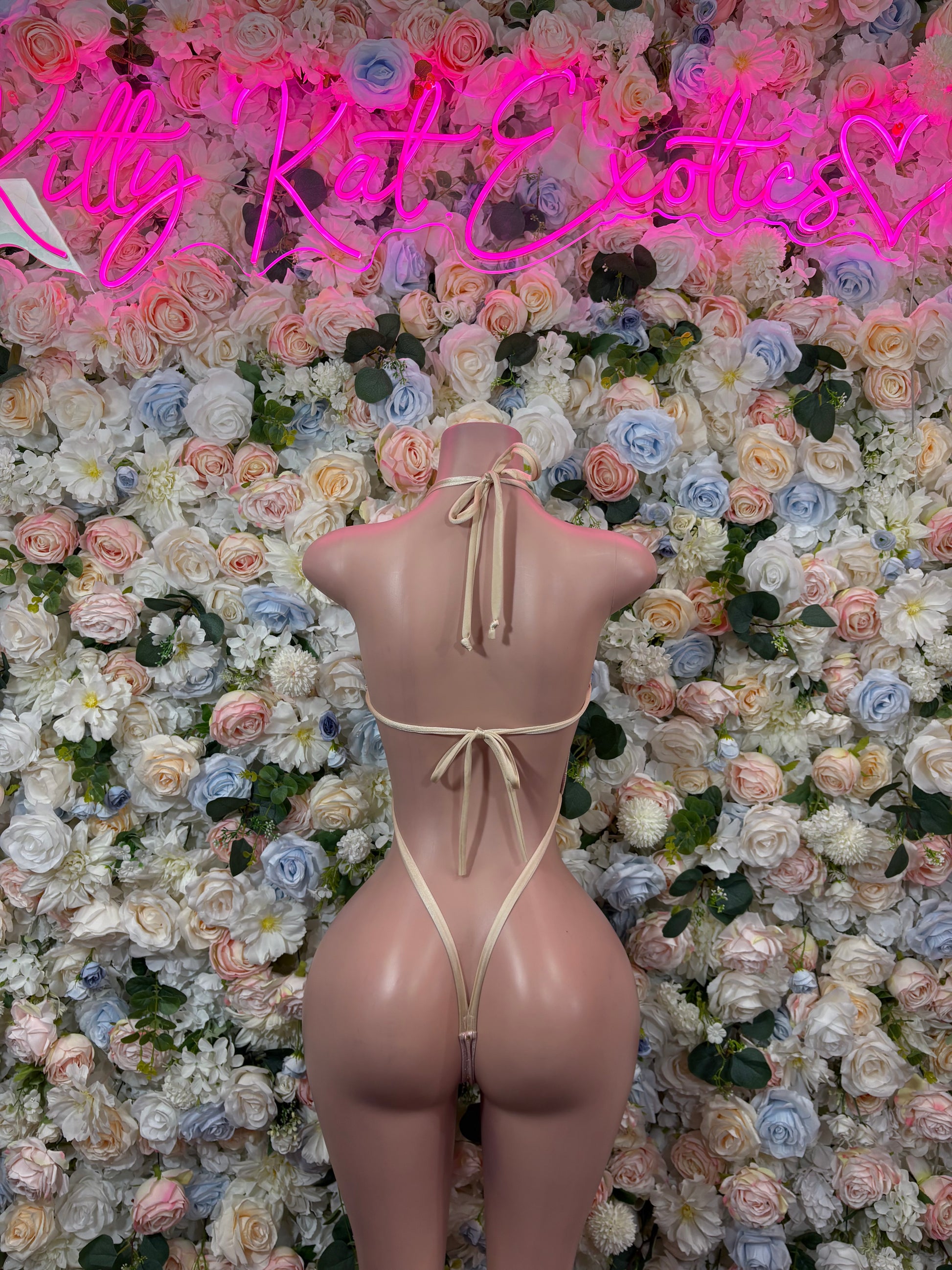 Nude open-back one-piece bodysuit with lace-up straps and thin chain back detail