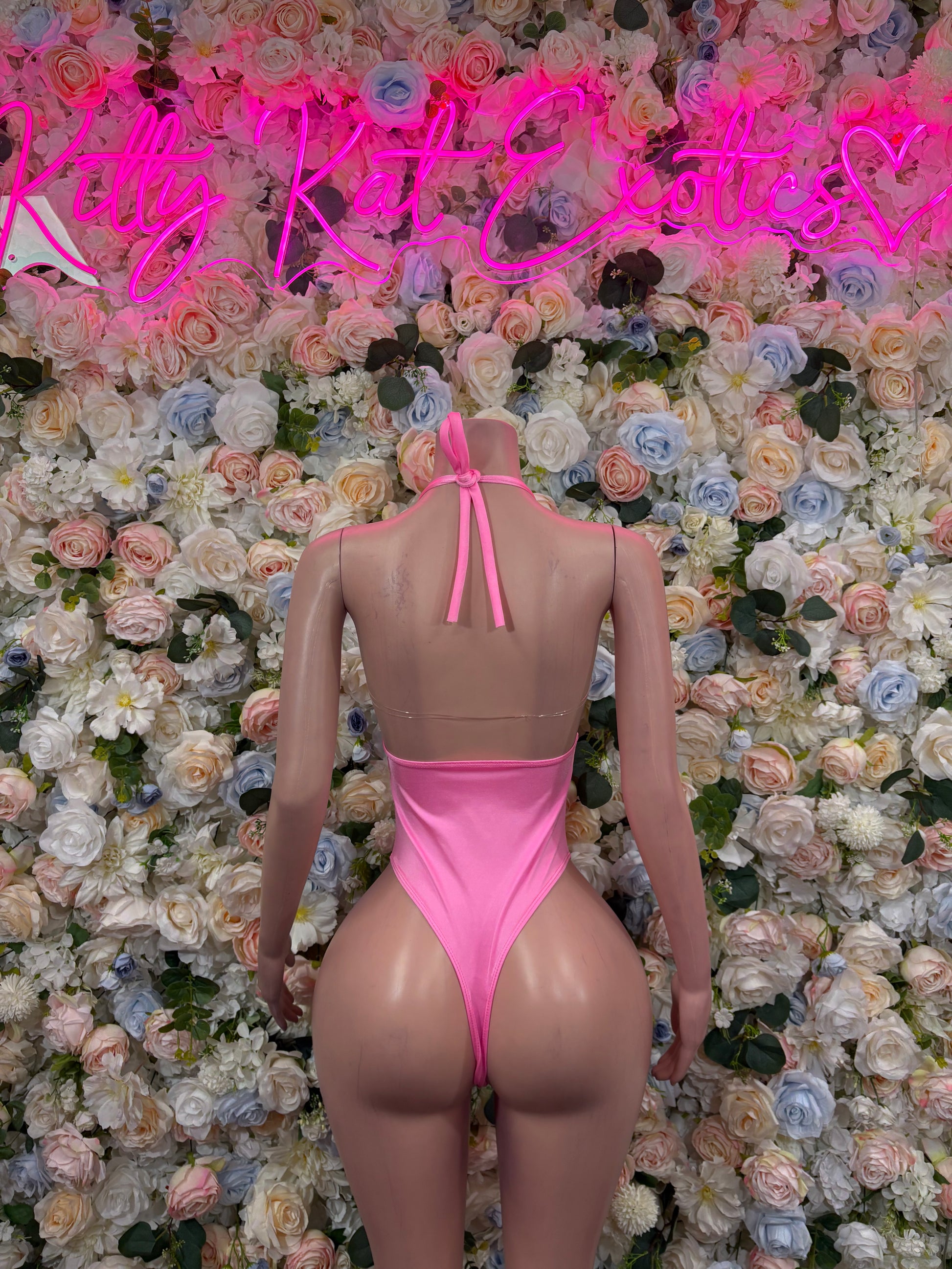 Pink open-back halter bodysuit with back tie and high-cut leg