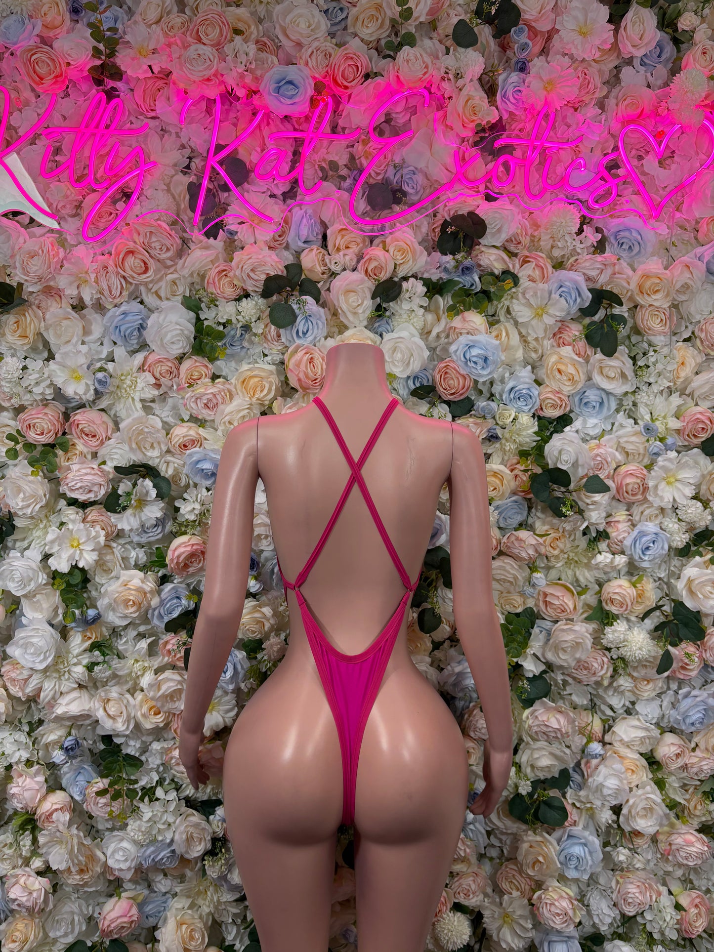 Pink high-cut bodysuit with crisscross X-back straps and back keyhole detail