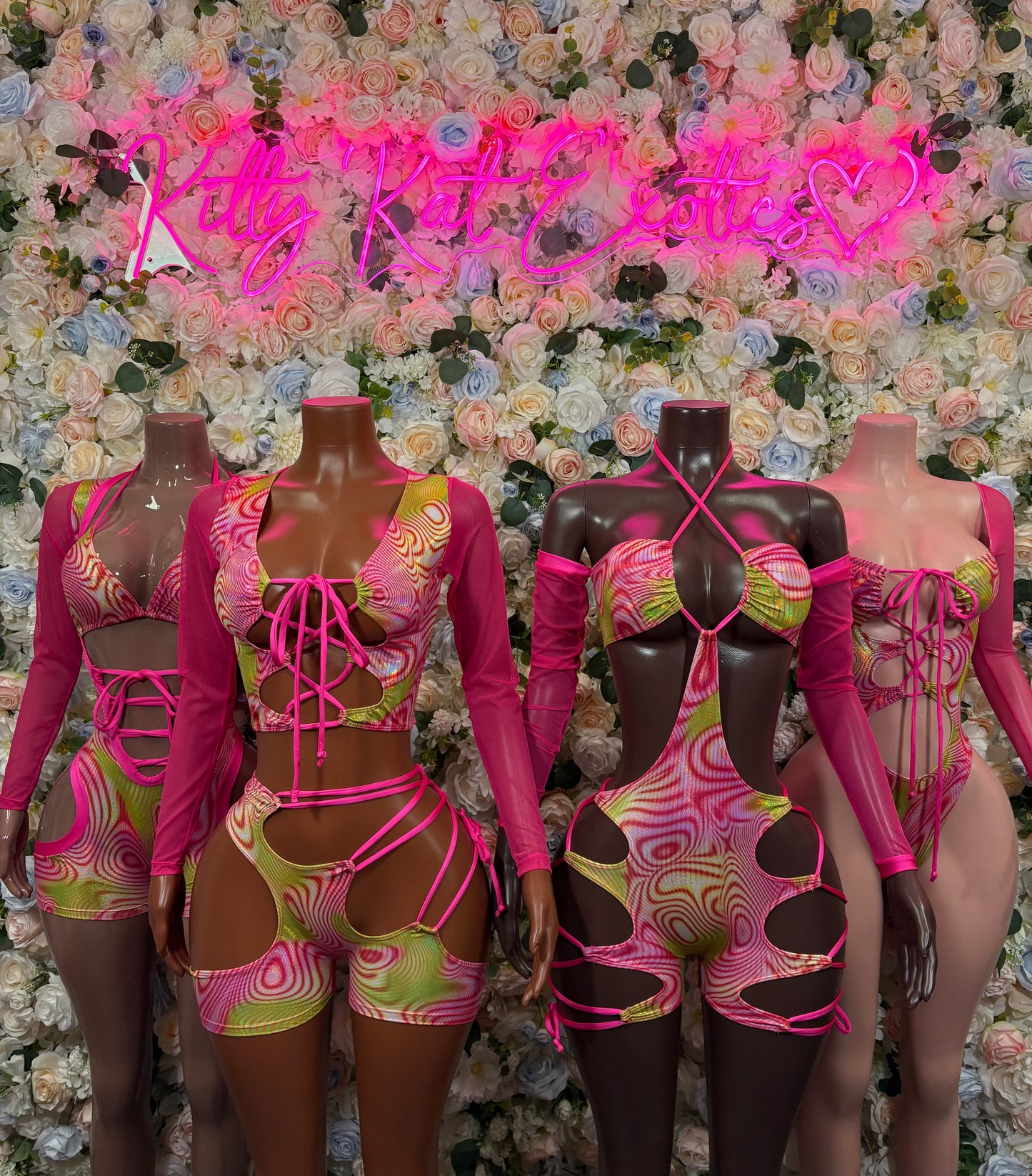 Three pink and black holographic dance bodysuits with long sleeves and strap cutouts