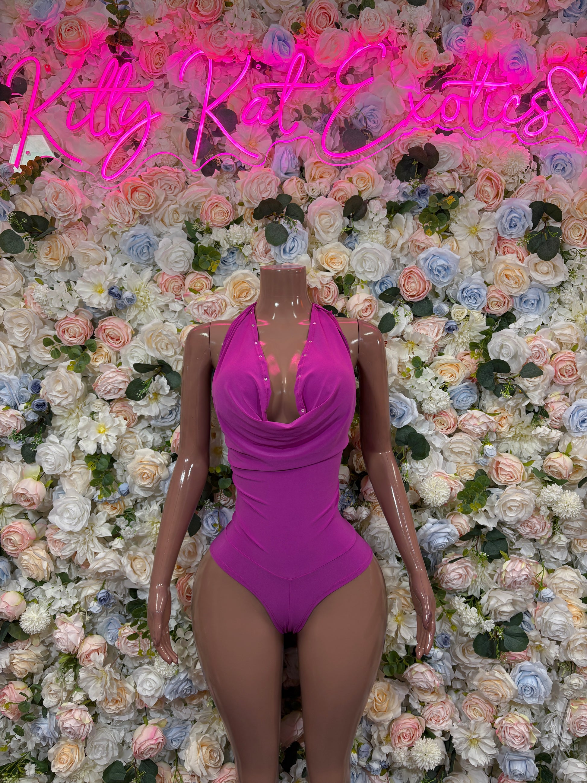 Purple one-piece rave bodysuit with cowl drape detail and V-shaped neckline