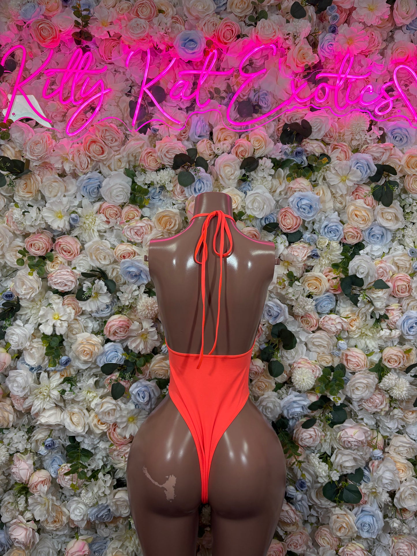 Orange one-piece bodysuit with back tie straps and open back detail