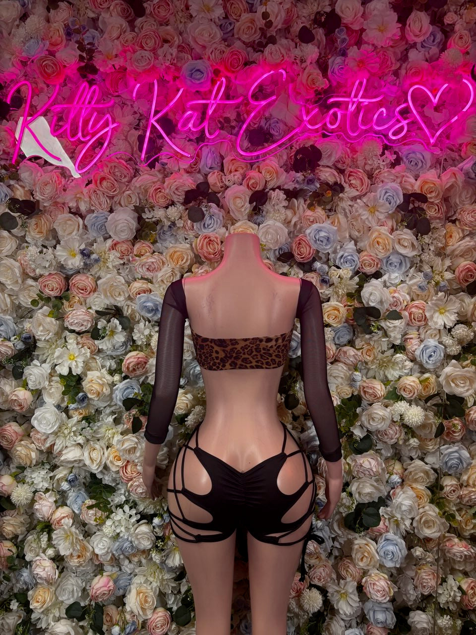 Leopard print bodysuit with bow details, strappy back cutouts, and long sleeves