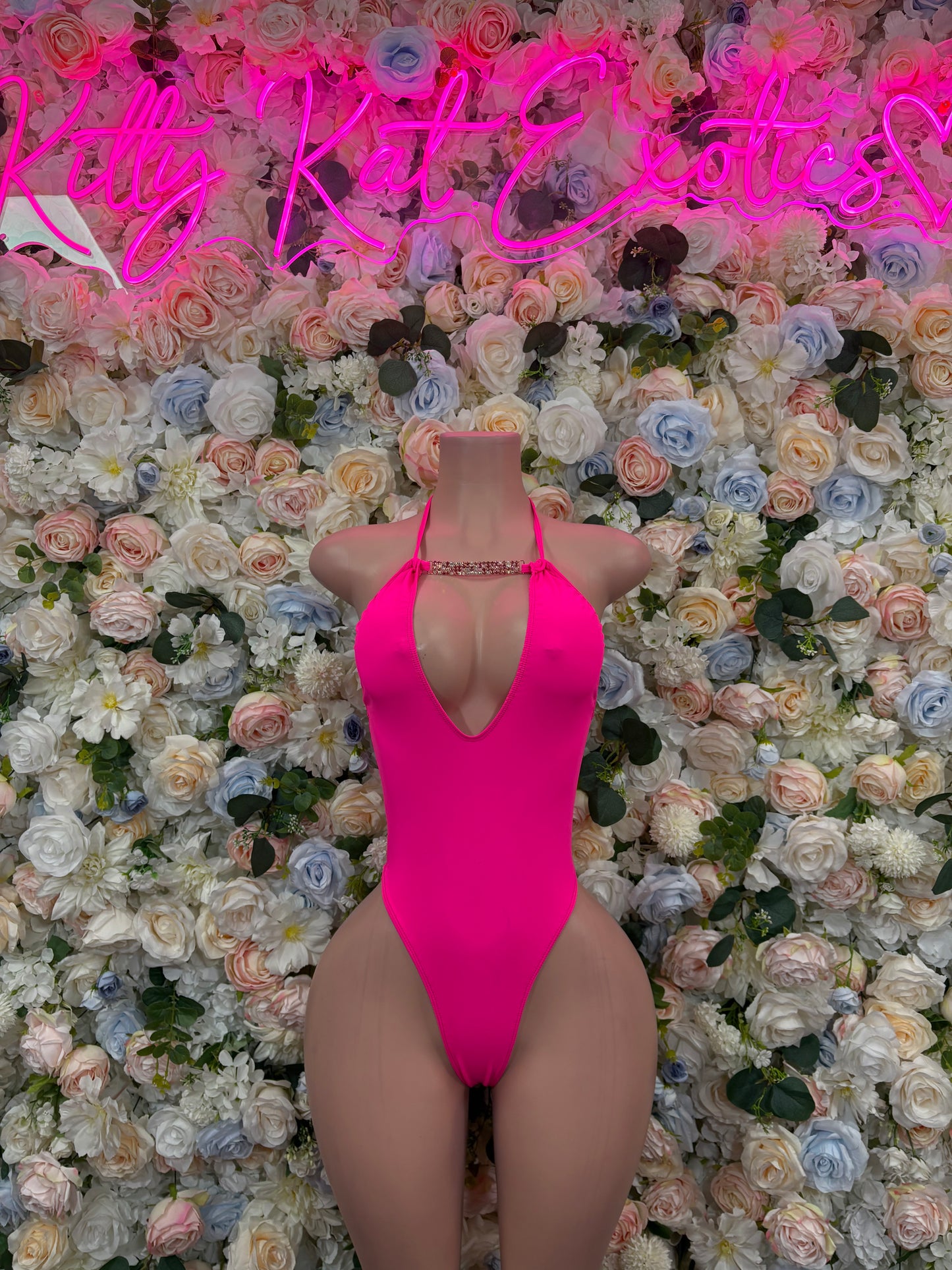 Hot pink sleeveless one-piece dancewear bodysuit with V-neck front and high-cut legs