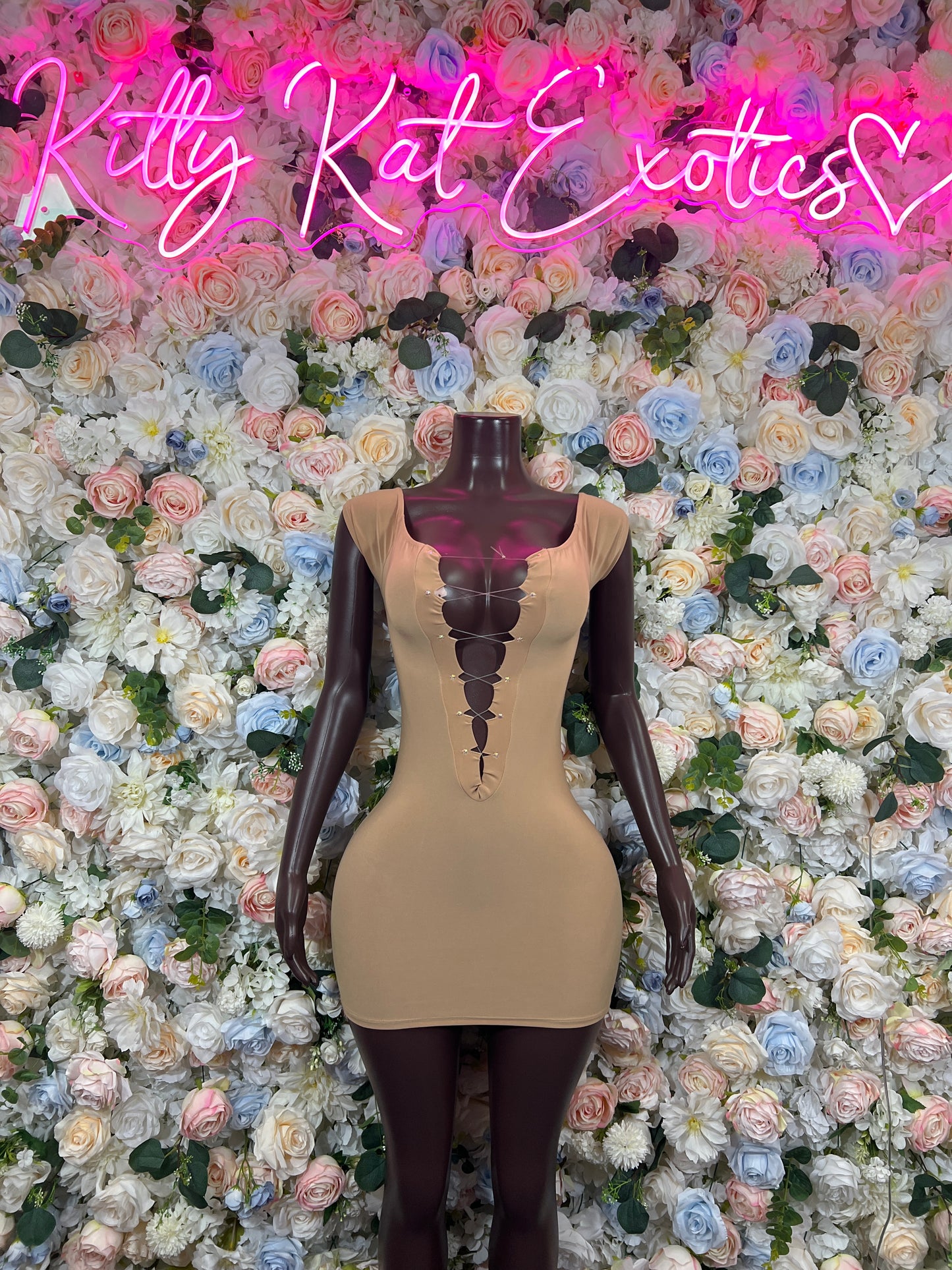 Nude sleeveless mini dress with corset-style paneling and crisscross front detail