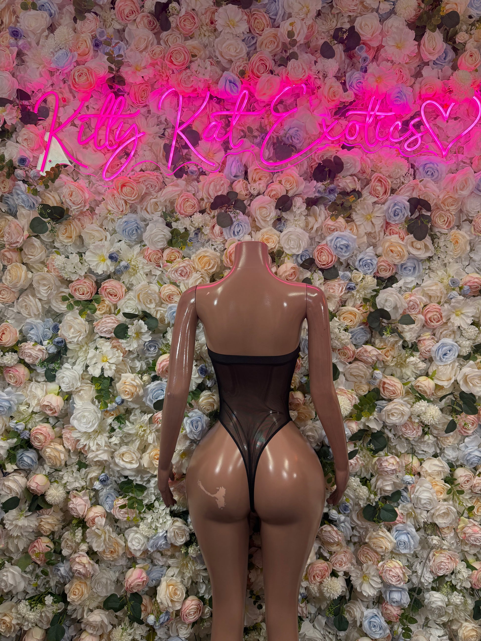 Black one-piece bodysuit with V-shaped back, cutout center, and high-leg coverage