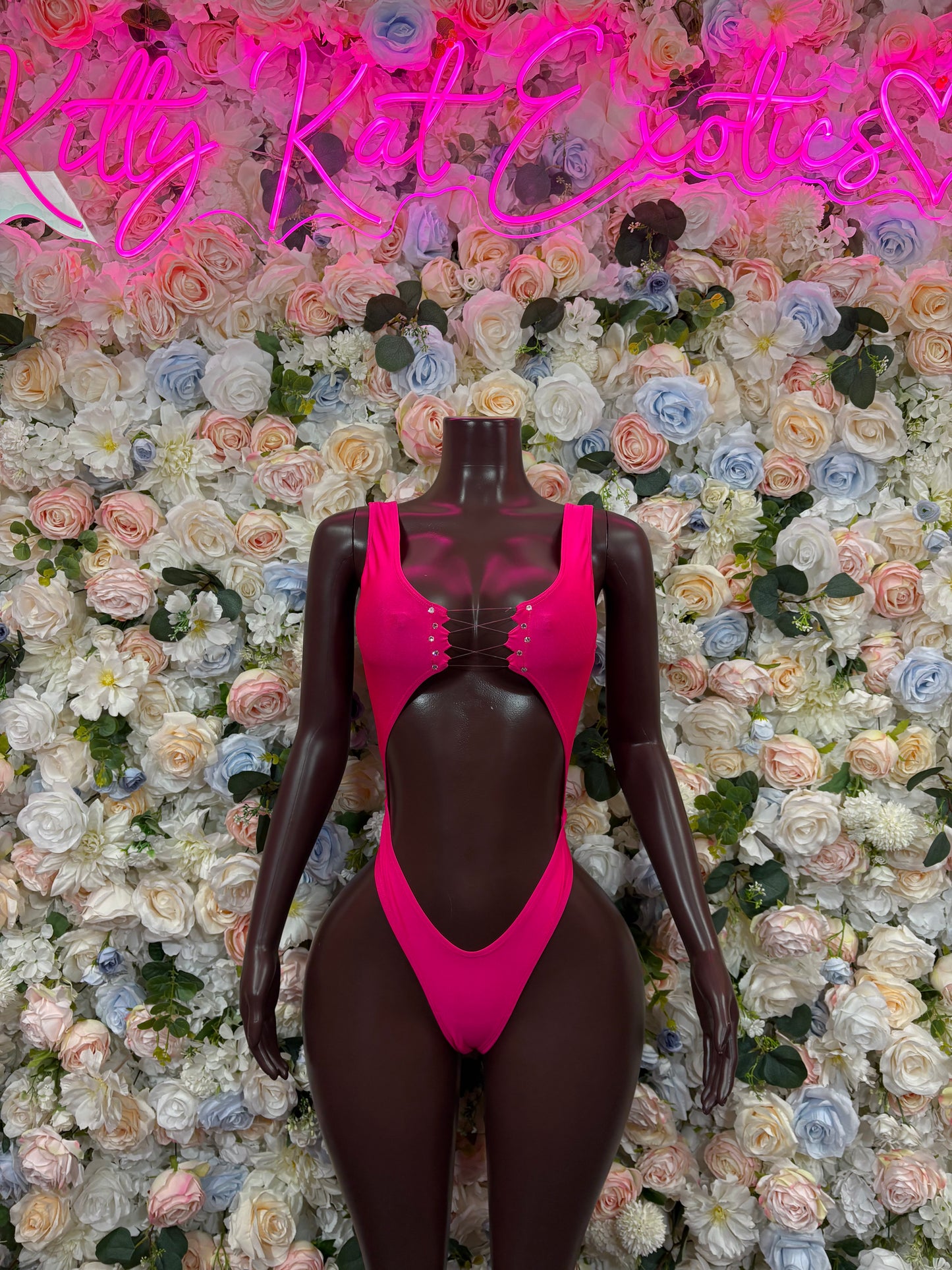 Pink sleeveless thong bodysuit with deep V neckline and high-cut leg