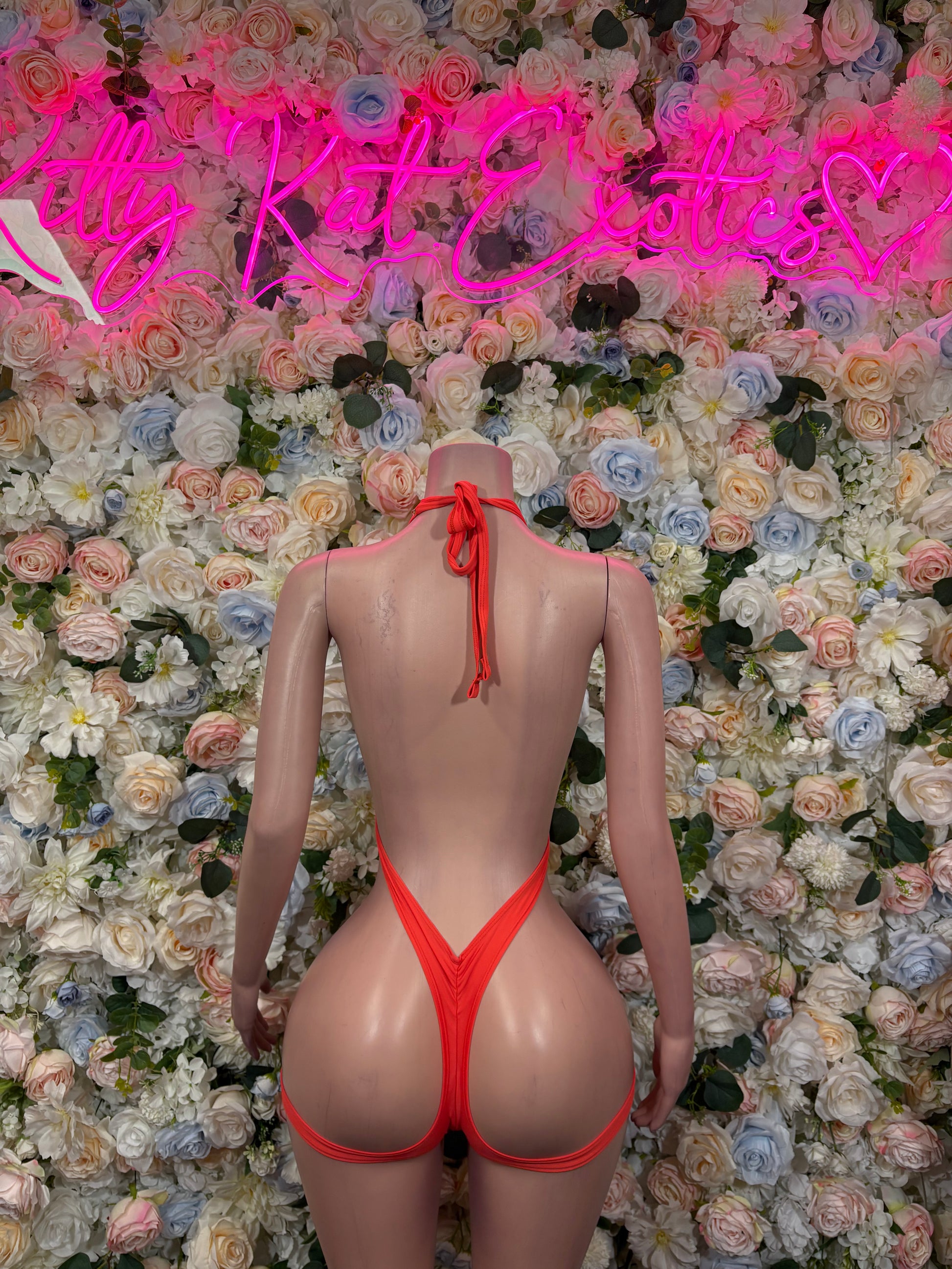 Orange-red halter one-piece bodysuit with high-cut legs and center-back tie