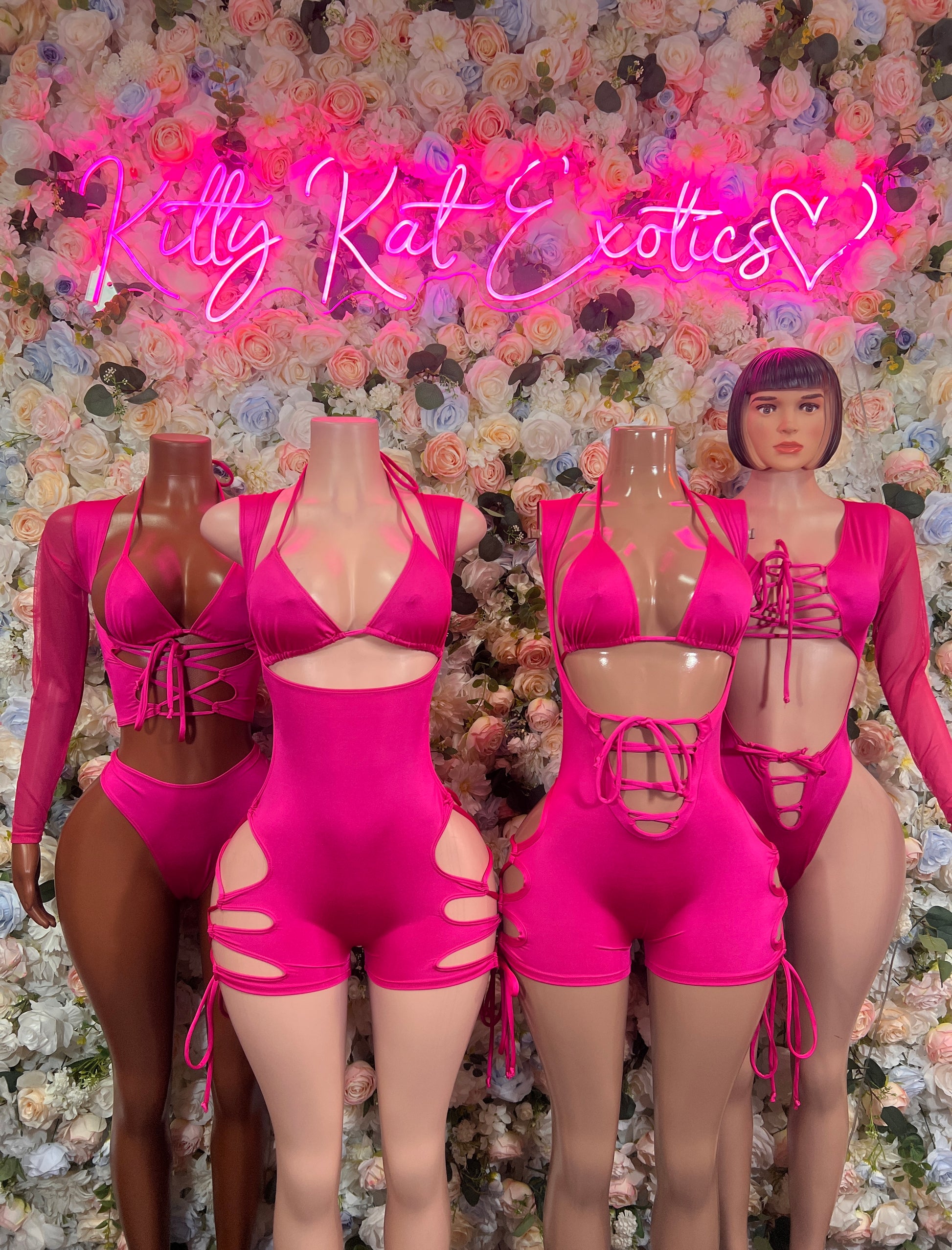 Pink Bottlegirl Bodysuit displayed on mannequins at Kitty Kat Exotics, featuring stylish dancewear.