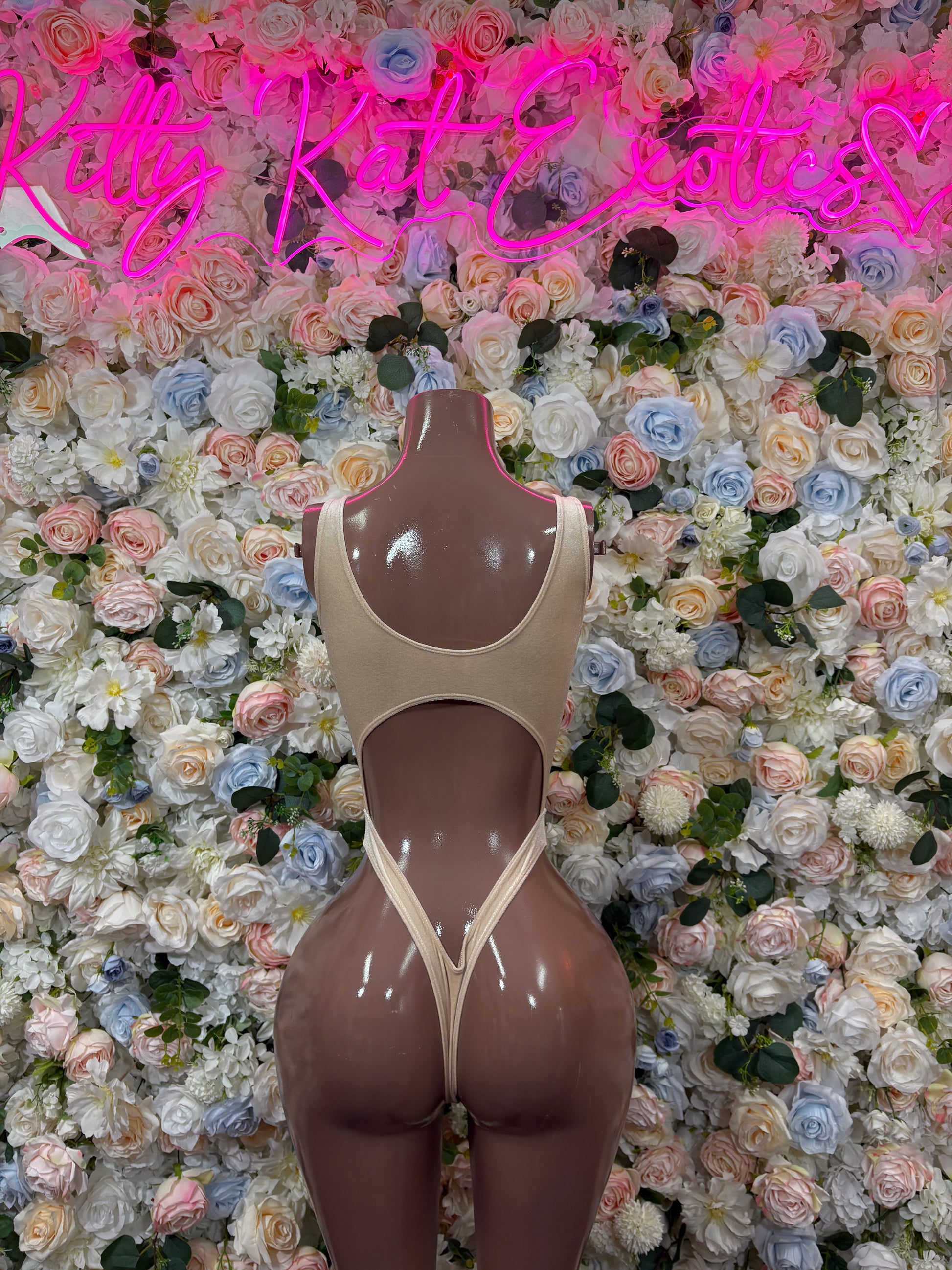 Tan bodysuit one-piece on mannequin, scoop front and cheeky high-cut leg