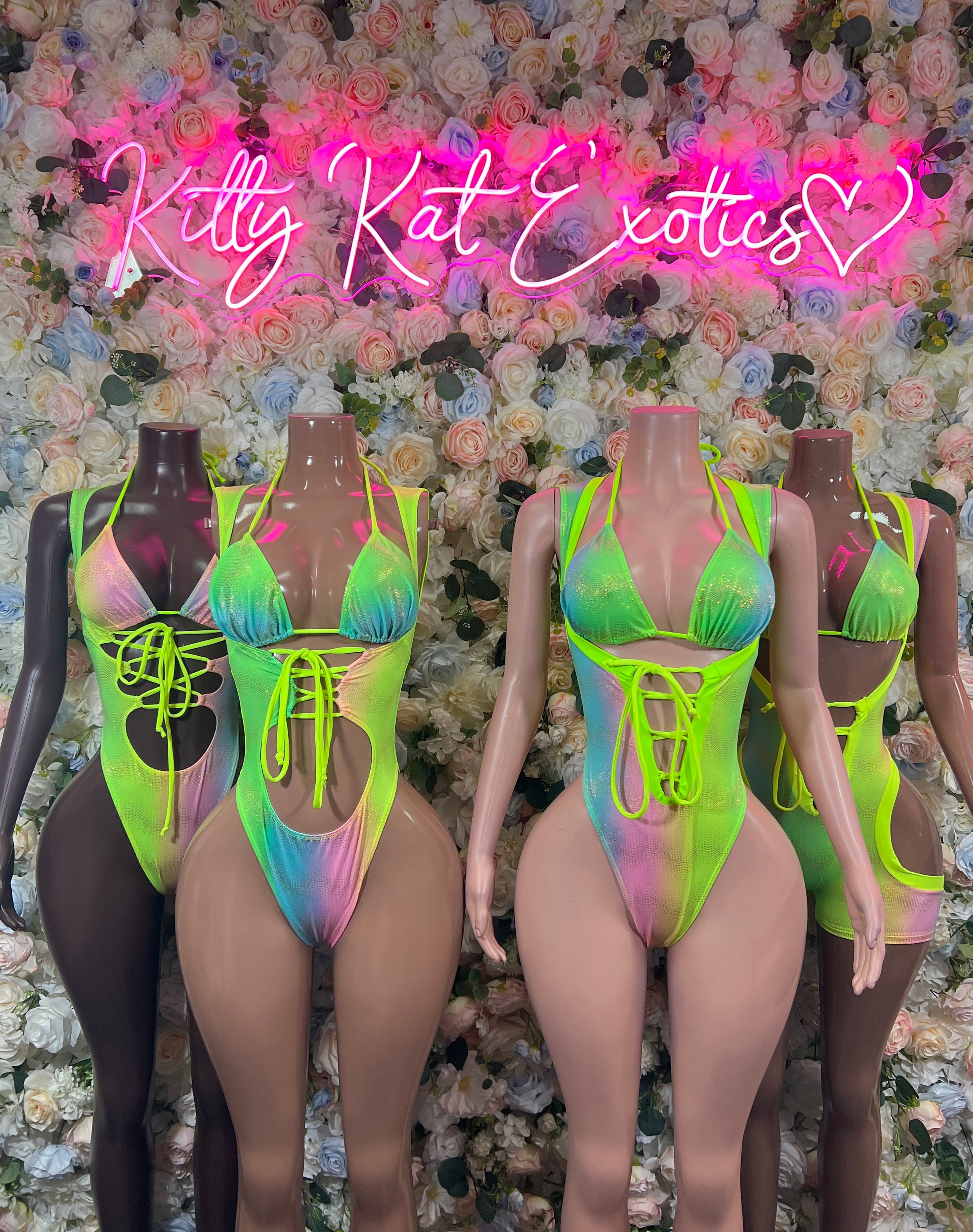 Holographic neon green lace-up bodysuit on mannequin, strappy V neckline