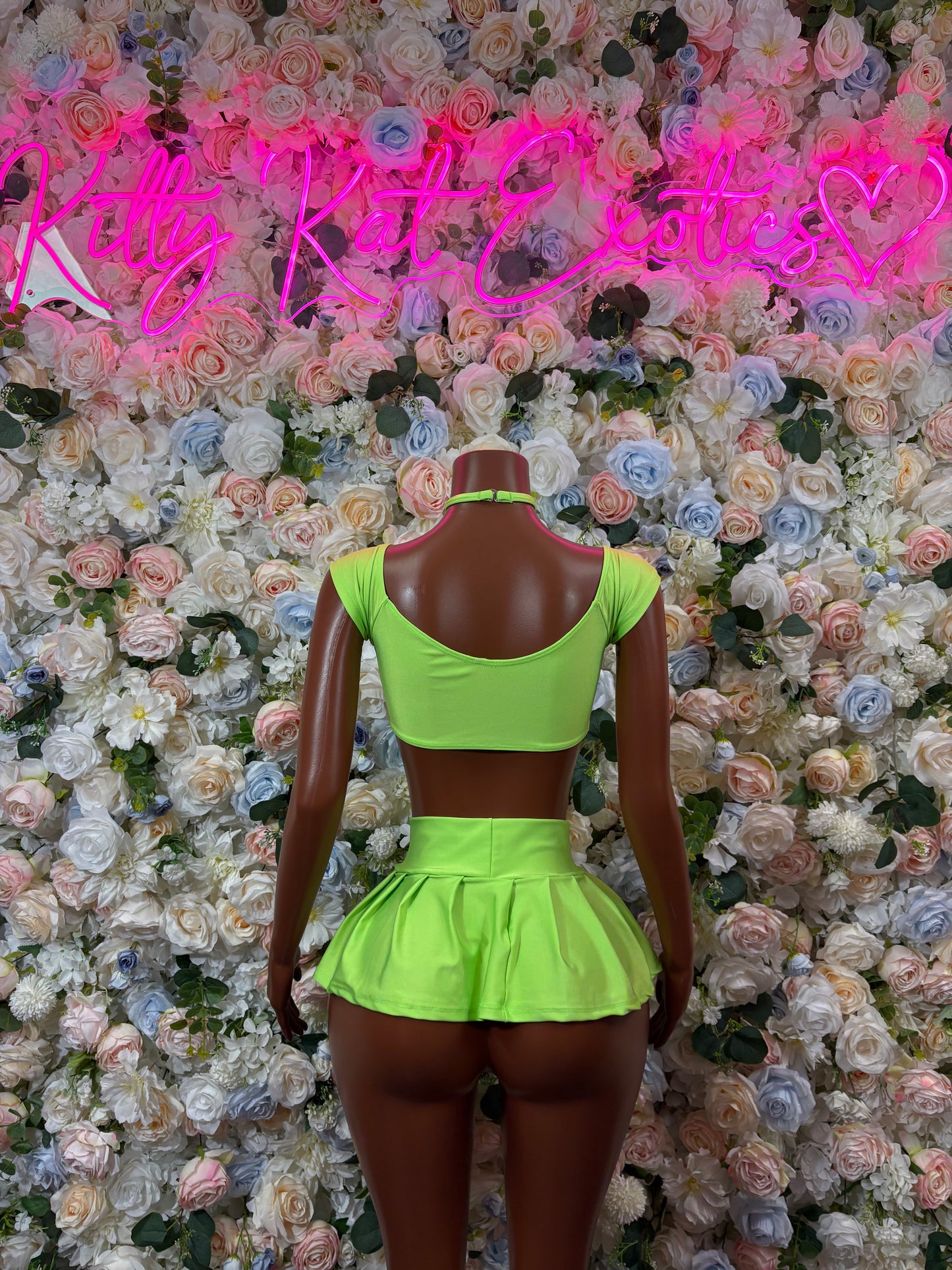 Green two-piece dancewear outfit with open-back crop top and flared mini skirt
