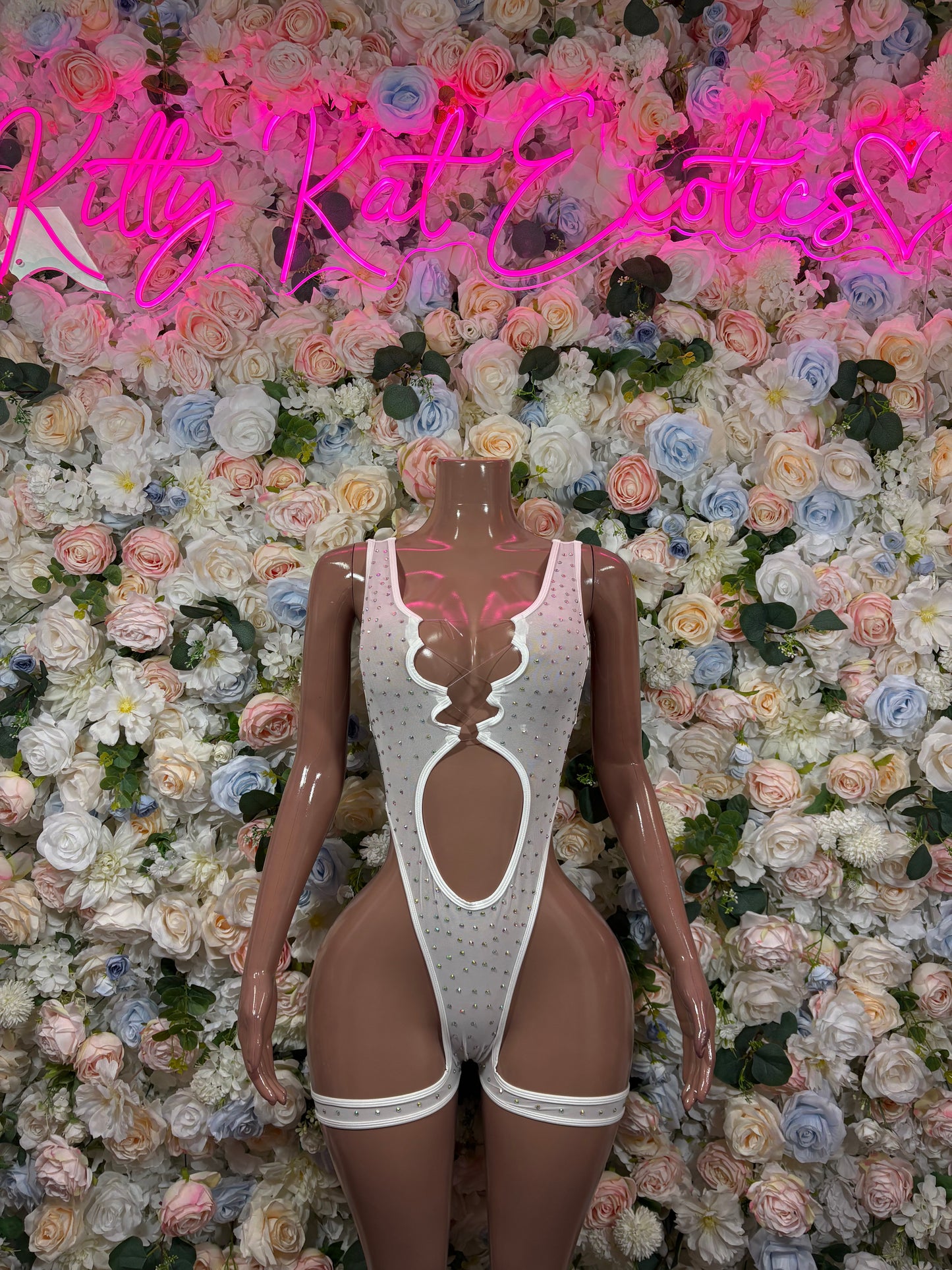 White rhinestone bodysuit on mannequin, deep V front and high-leg cutout straps