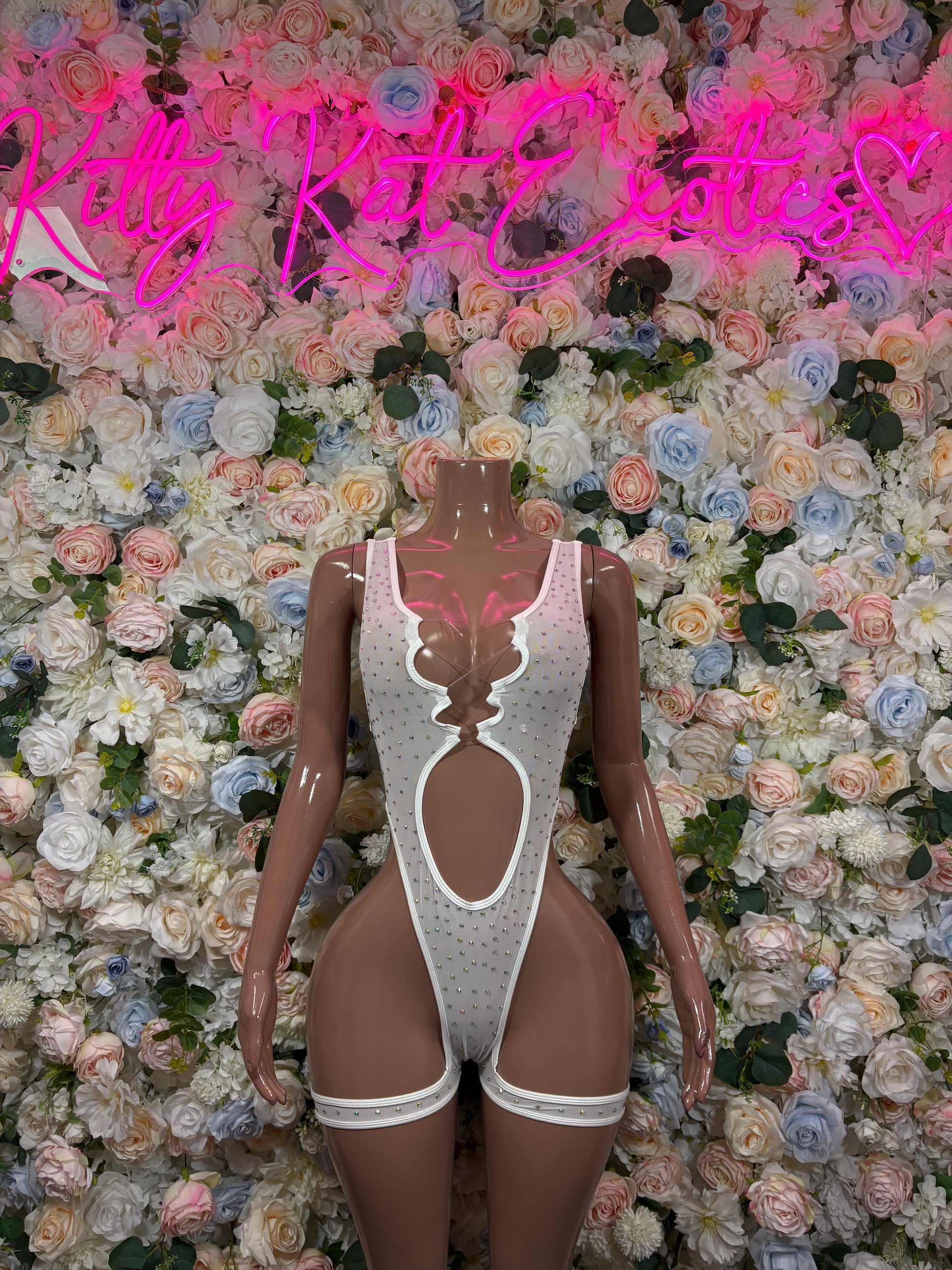 White rhinestone bodysuit on mannequin, deep V front and high-leg cutout straps
