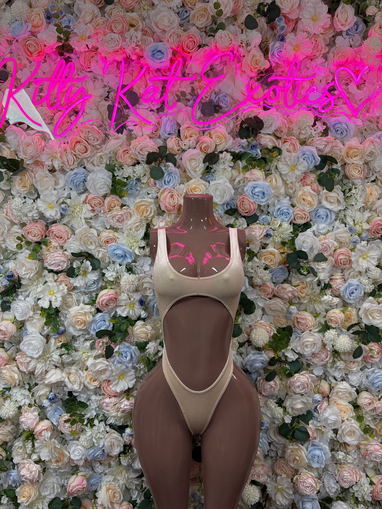 Tan bodysuit one-piece on mannequin, high-cut legs and scoop front