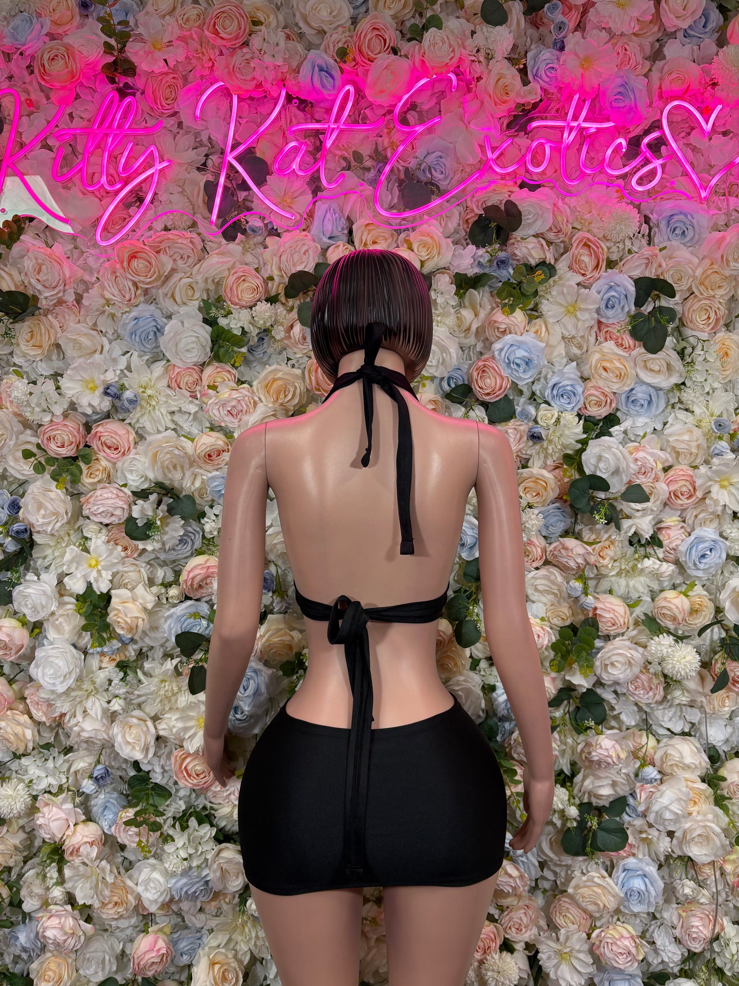 Black backless halter bodysuit with mini skirt, back view
