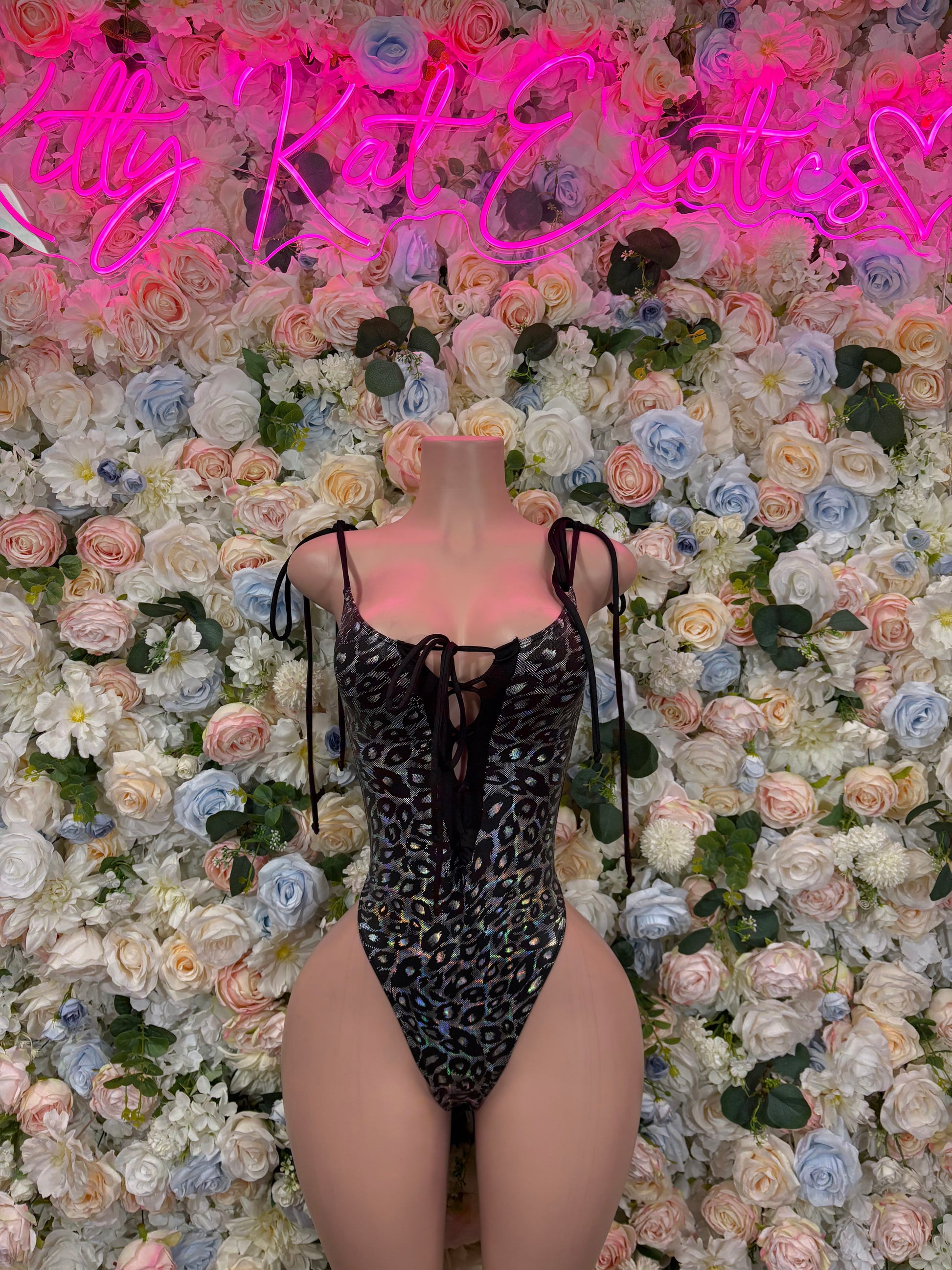 Black printed one-piece bodysuit with lace-up shoulder straps and thong-style legs