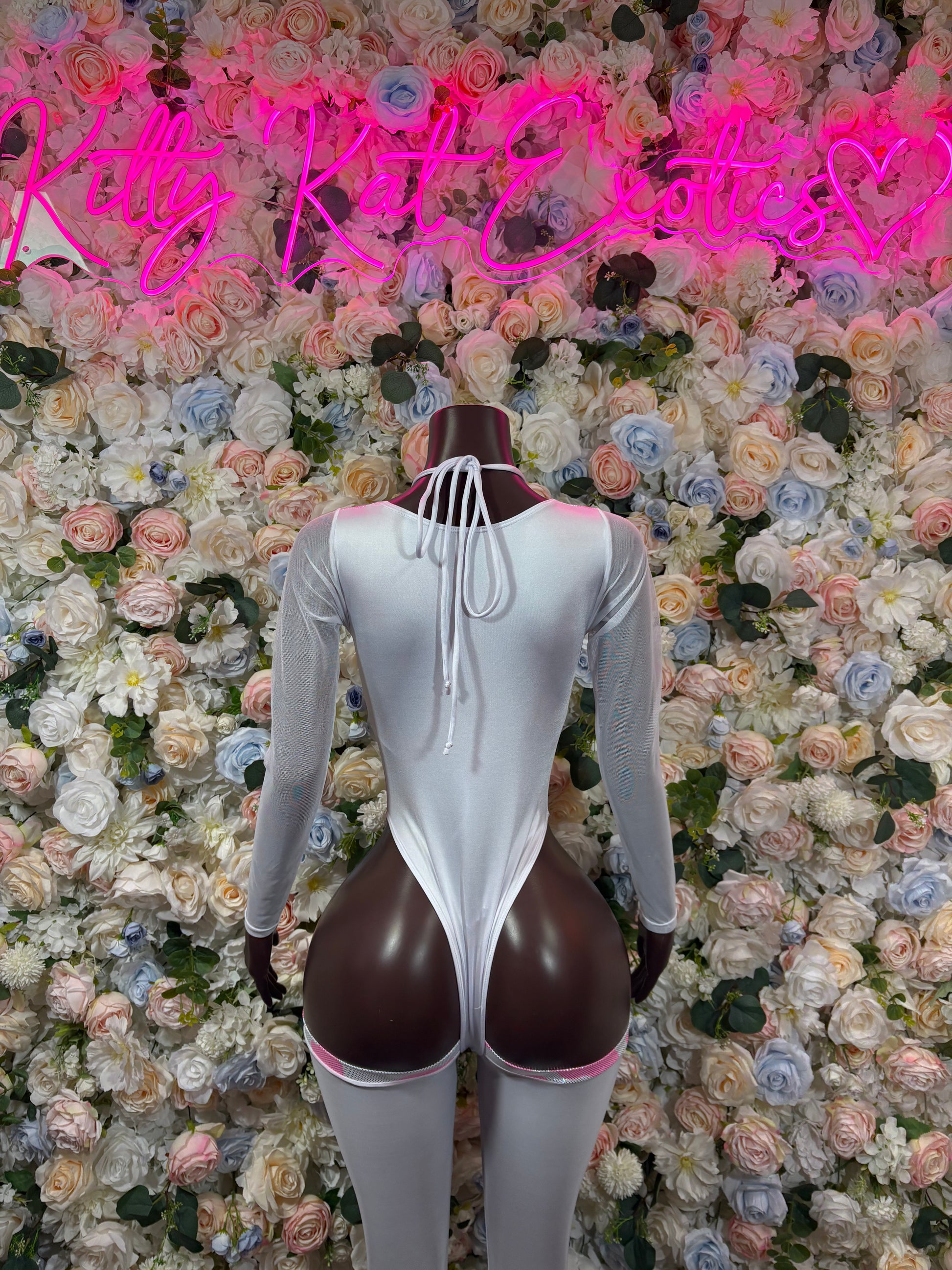 White and pink cow-print bodysuit with long sleeves and crisscross lace back