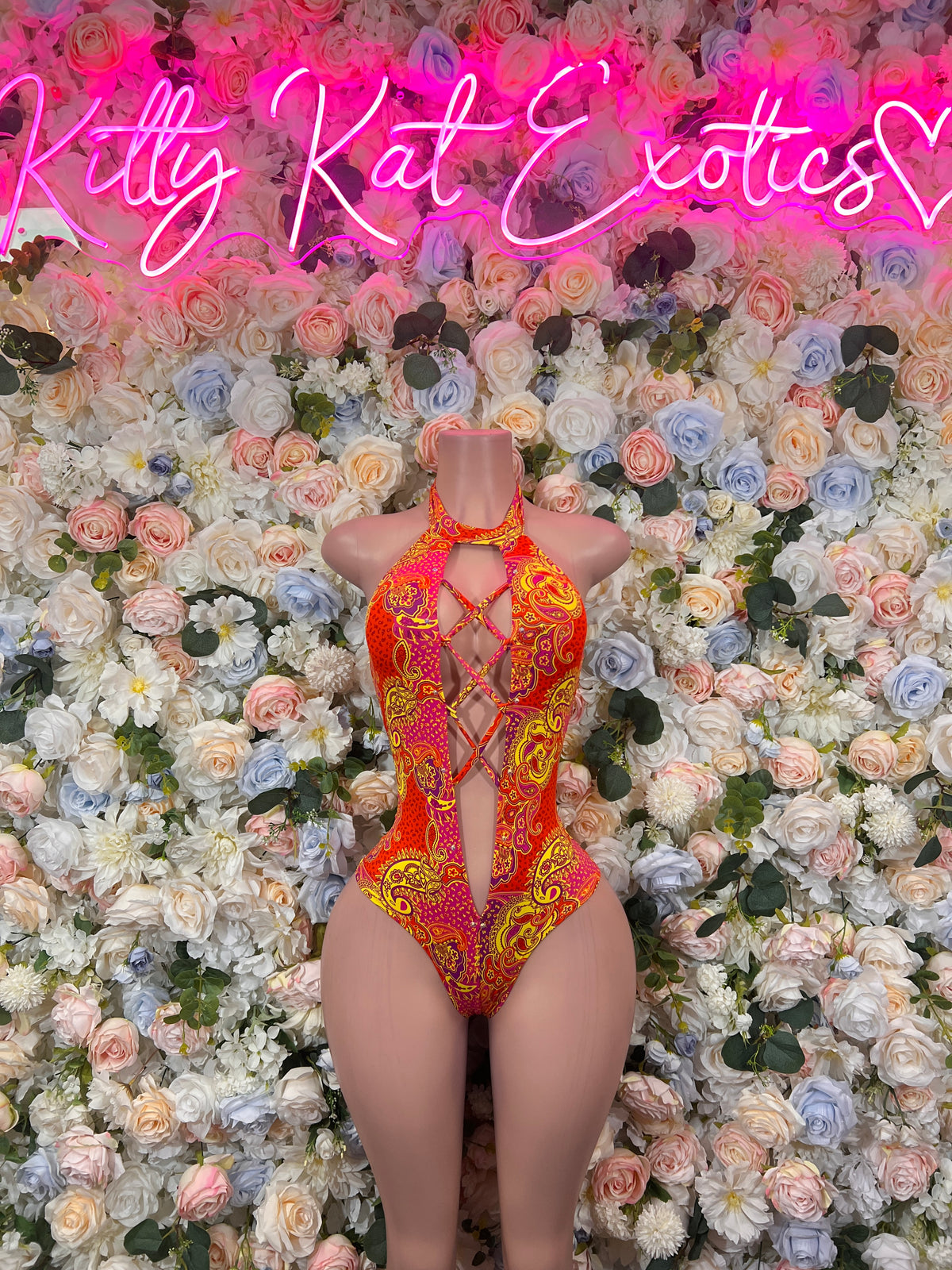 Orange patterned one-piece bodysuit with halter straps and high-cut leg