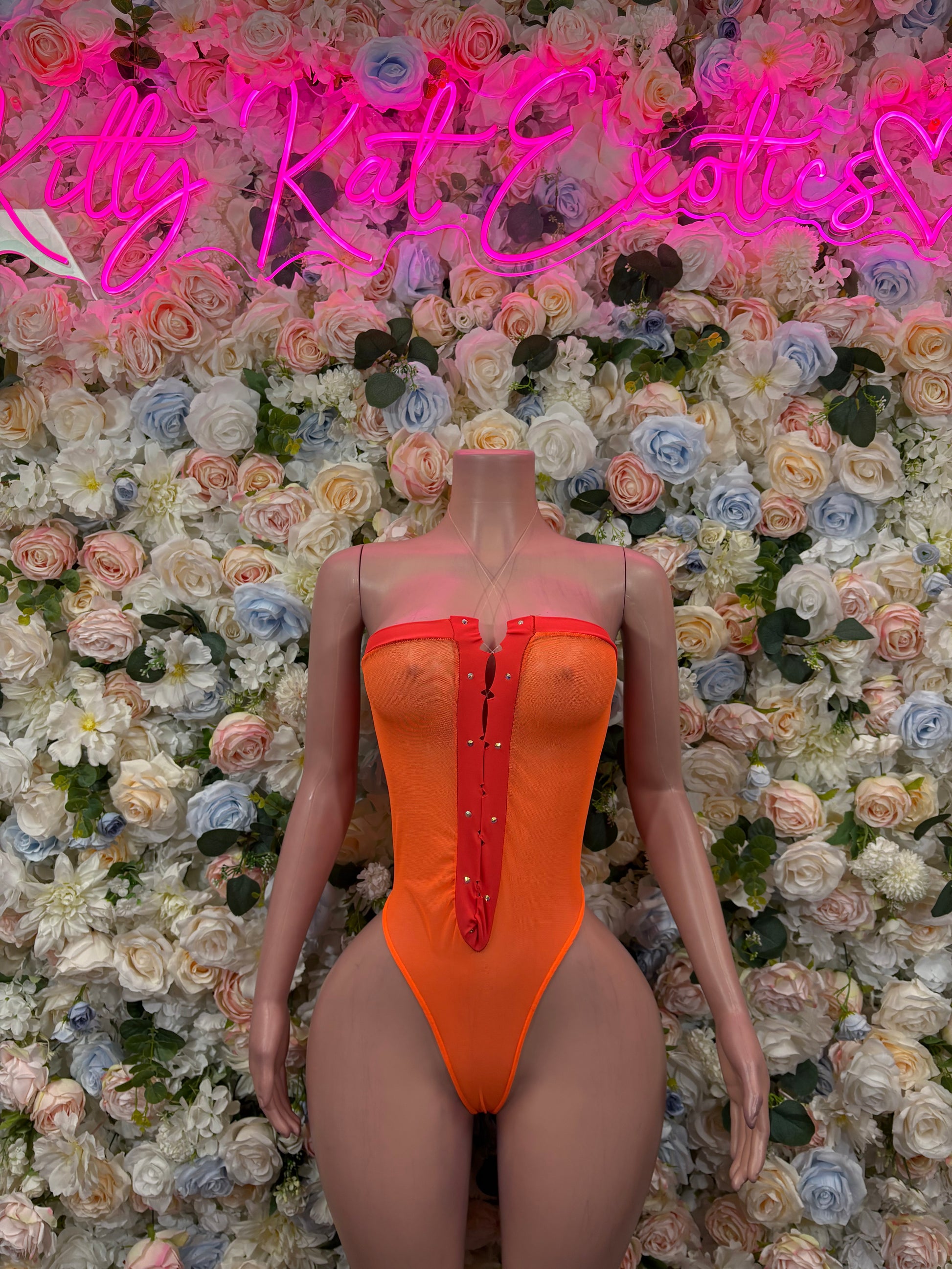 Orange one-piece bodysuit with red zipper detail and high-cut legs