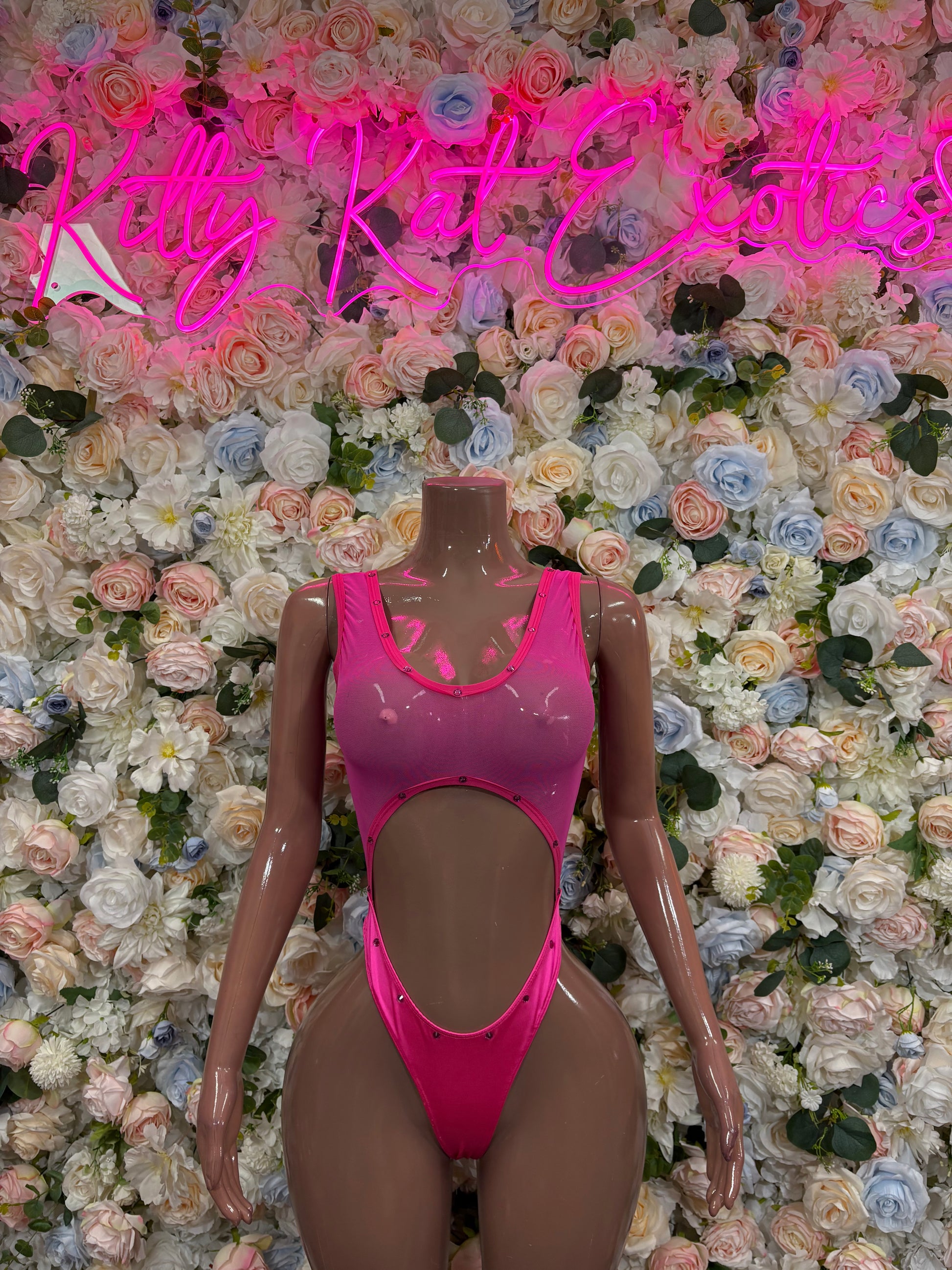 Pink one-piece bodysuit with keyhole cutout at chest and high-cut leg openings