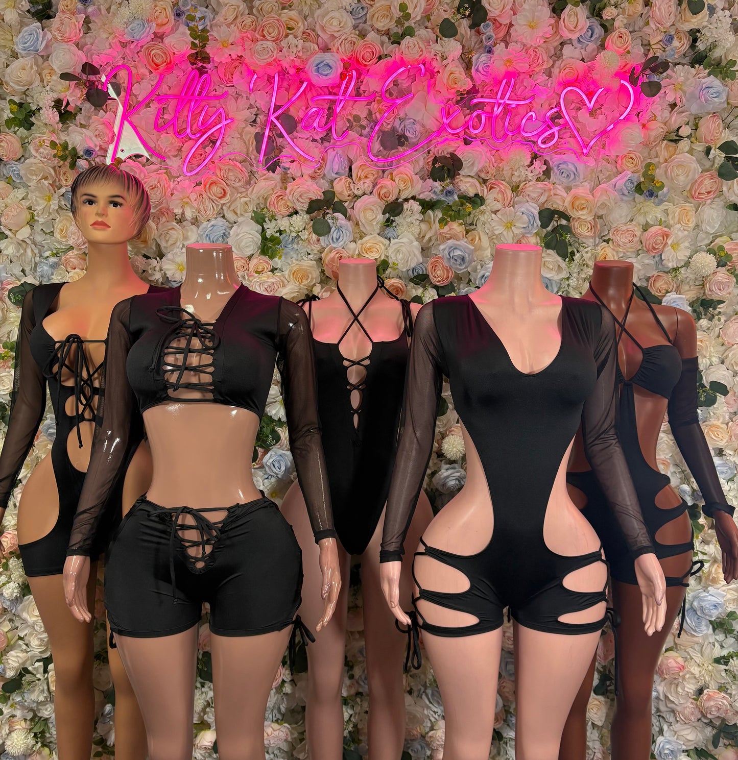 Black lace-up bodysuit with long sleeves and cutout details on mannequins