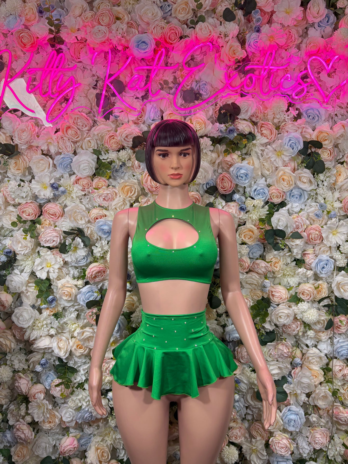 Green two-piece skirt set with cutout halter crop top and flared mini skirt, front view