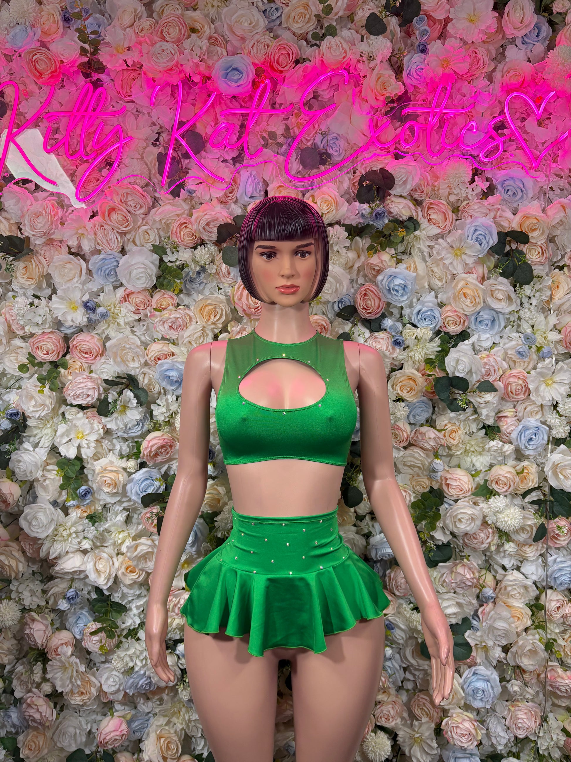 Green two-piece skirt set with cutout halter crop top and flared mini skirt, front view
