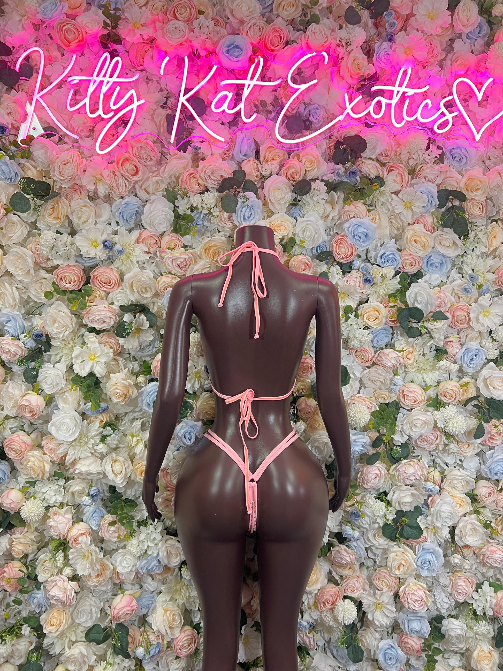 Pink rhinestone bikini set with triangle top and open-back bottoms on mannequin