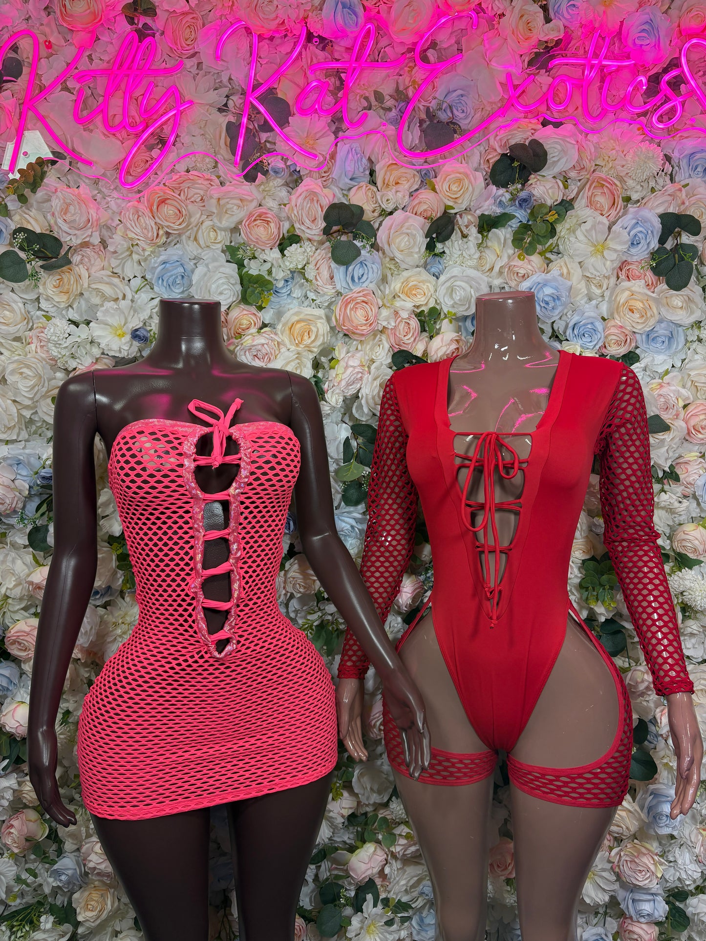 Red corset-style mini dress and lace-up bodysuit on mannequins, both with cutouts