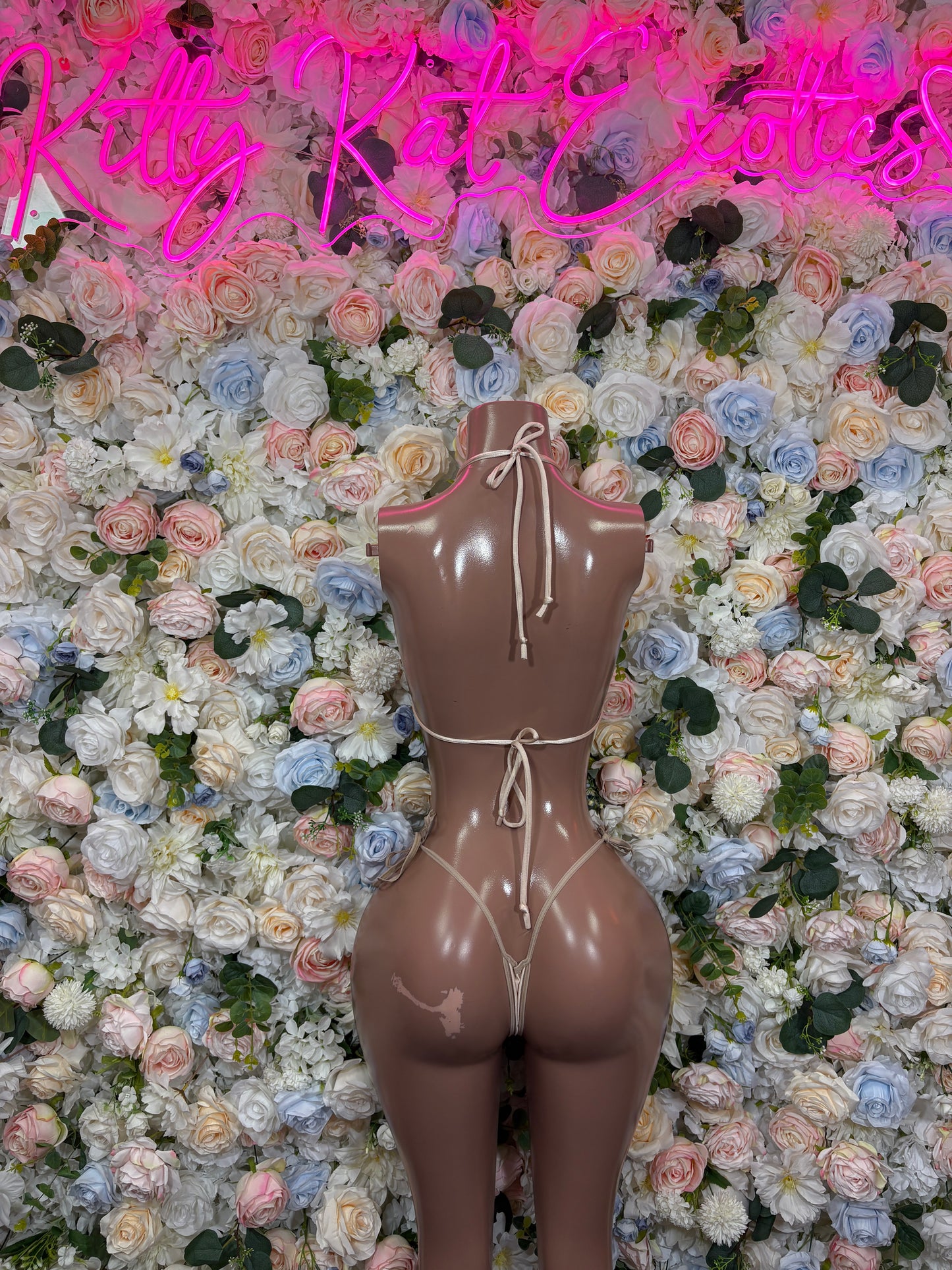 Nude two-piece bikini with triangle cups, tie strings, and minimal bottom