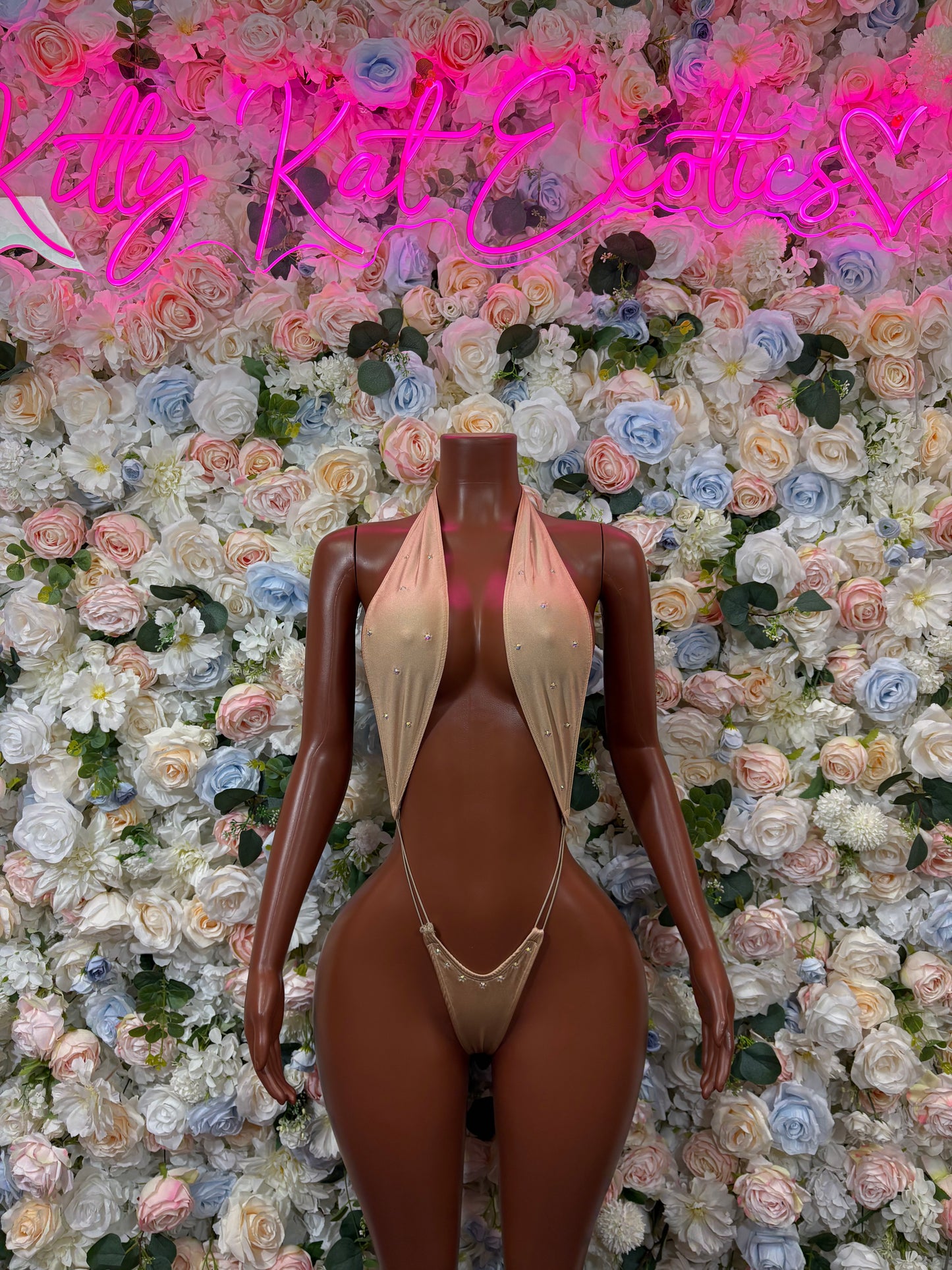 Tan slingshot bodysuit with deep front cutout and strappy back.
