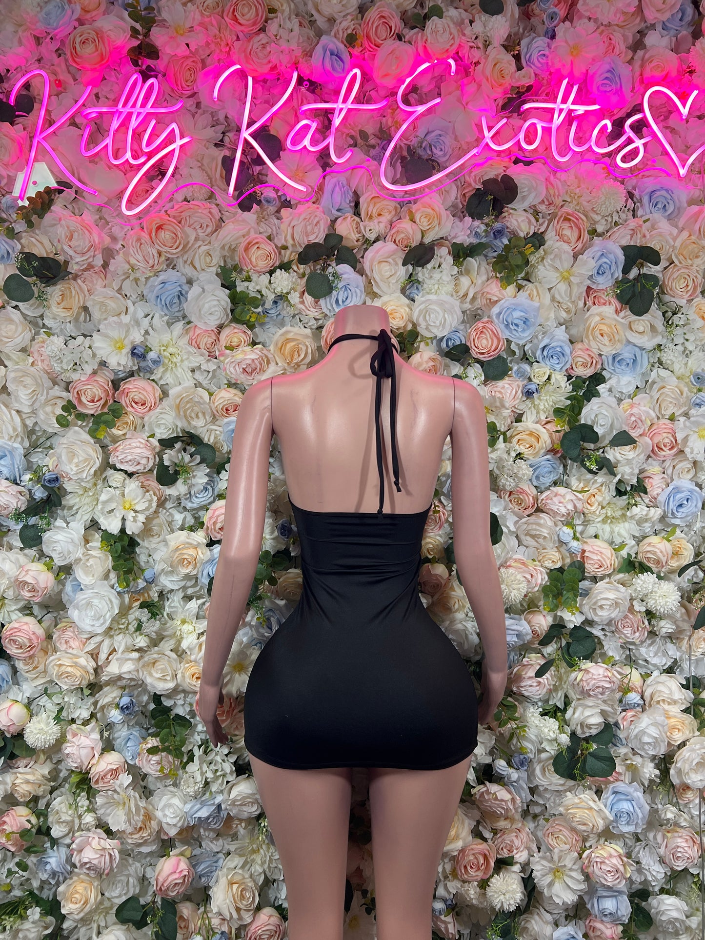 Back view of black backless mini dress with halter tie straps and narrow shoulder ties